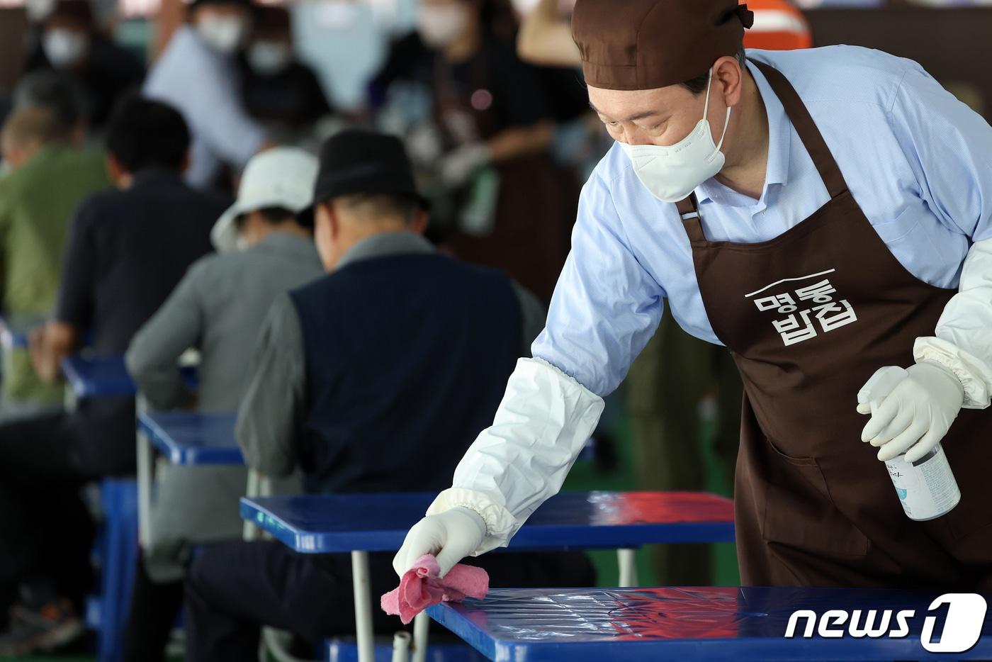 윤석열 대통령이 추석 연휴 첫날인 9일 서울 중구 명동성당 내 노숙인·홀몸어르신을 위한 무료급식소 &#39;명동밥집&#39;을 찾아 테이블을 닦고 있다. &#40;대통령실 제공&#41; 2022.9.9/뉴스1 ⓒ News1 안은나 기자