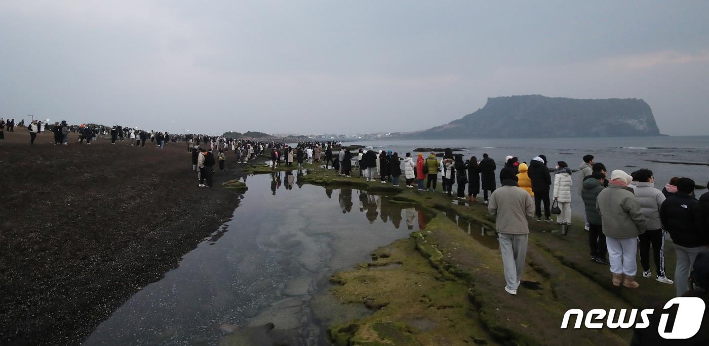 제주 서귀포시 성산읍 광치기해변에서 시민들이 성산일출봉을 바라보며 새해 첫 일출을 기다리고 있다. 2023.1.1/뉴스1 ⓒ News1 오현지 기자