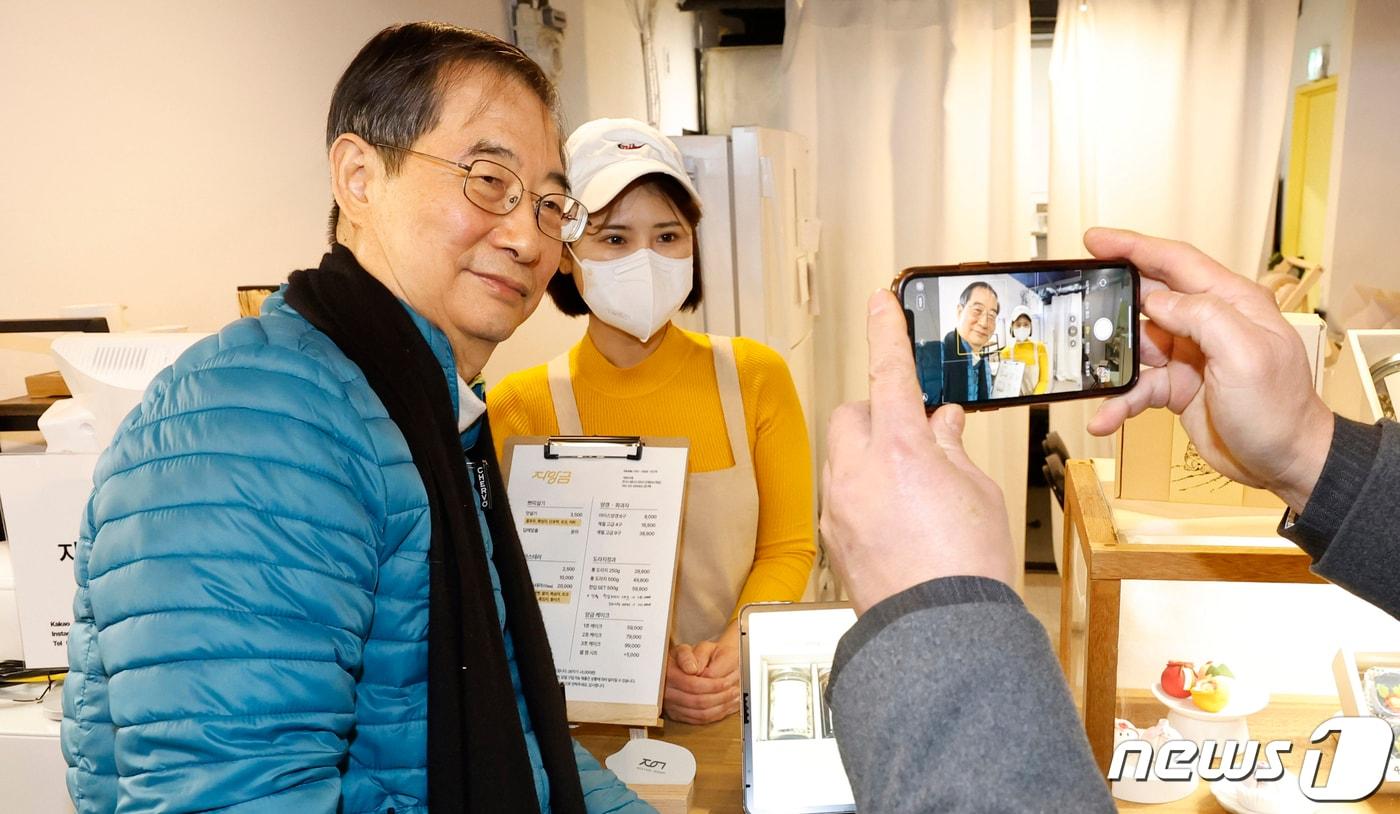 한덕수 국무총리가 18일 설 명절 대비 민생현장 방문을 위해 서울 동대문구 경동시장 청년몰을 방문해 청년상인과 기념촬영을 하고 있다. &#40;공동취재&#41; 2023.1.18/뉴스1 ⓒ News1 김명섭 기자