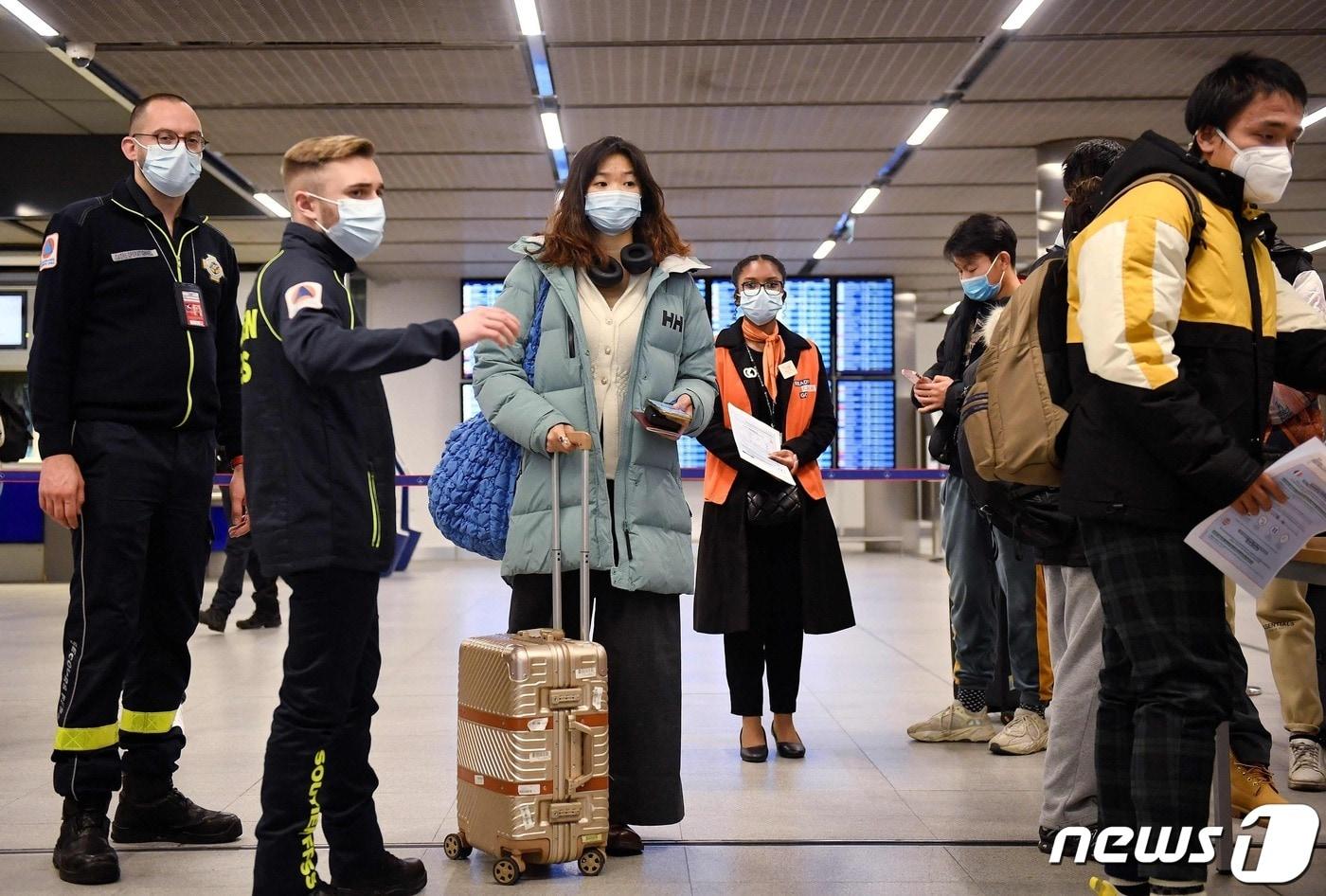 1월1일 파리 샤를드골 공항에서 중국발 여객기 탑승객이 백신 증명서를 보여주기 위해 줄서있다.  ⓒ AFP=뉴스1