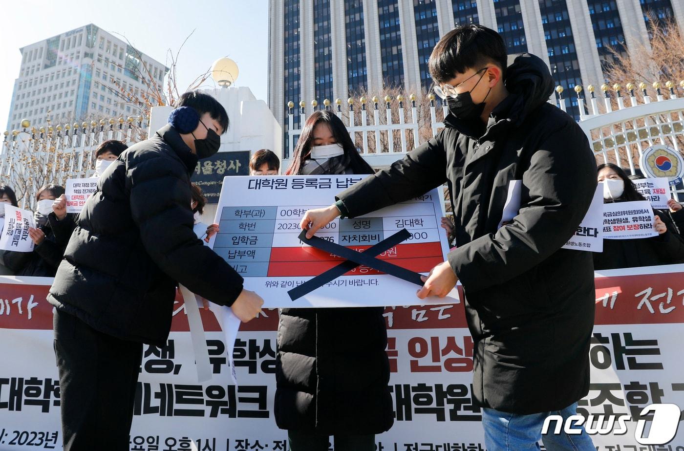 전국대학학생회네트워크와 전국대학원생노동조합 관계자들이 27일 오후 서울 종로구 정부서울청사 앞에서 대학원생, 유학생 등록금 인상을 규탄하는 기자회견을 열고 정부에 고등교육 재정 지원에 대한 책임을 촉구하며 퍼포먼스를 하고 있다. 2023.1.27/뉴스1 ⓒ News1 김도우 기자