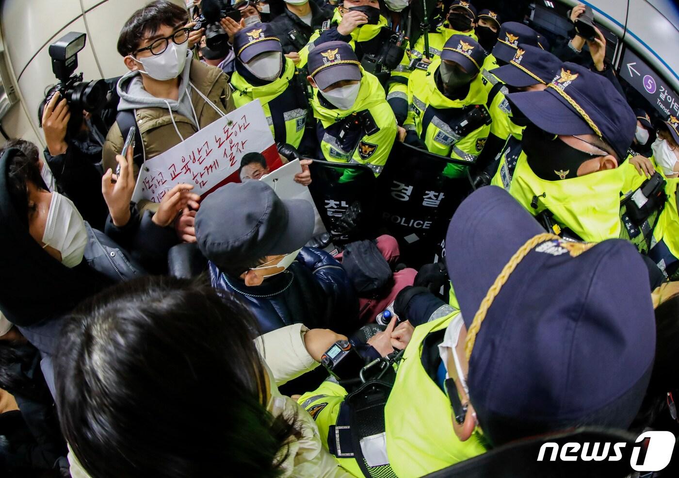 전장연 활동가들이 동대문역사공원역에서 홍보물을 부착하다 경찰의 제지를 받고 있다. 2023.1.3/뉴스1 ⓒ News1 김도우 기자