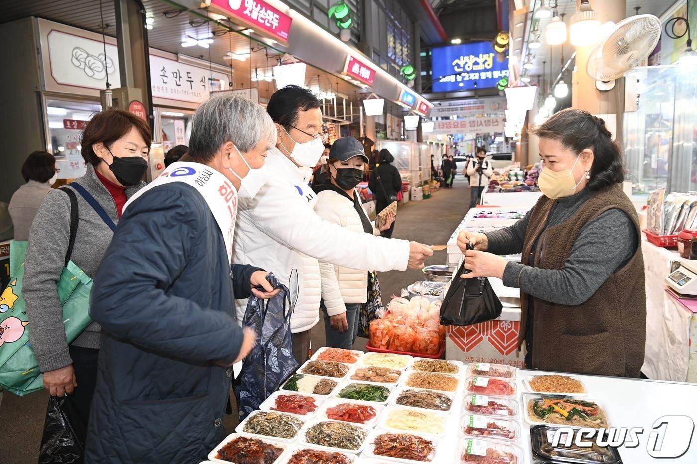 이현재 하남시장&#40;흰색 상의&#41;이 한 재래시장에서 지역화폐 하머니로 물건을 사고 있다.&#40;하남시 제공&#41;