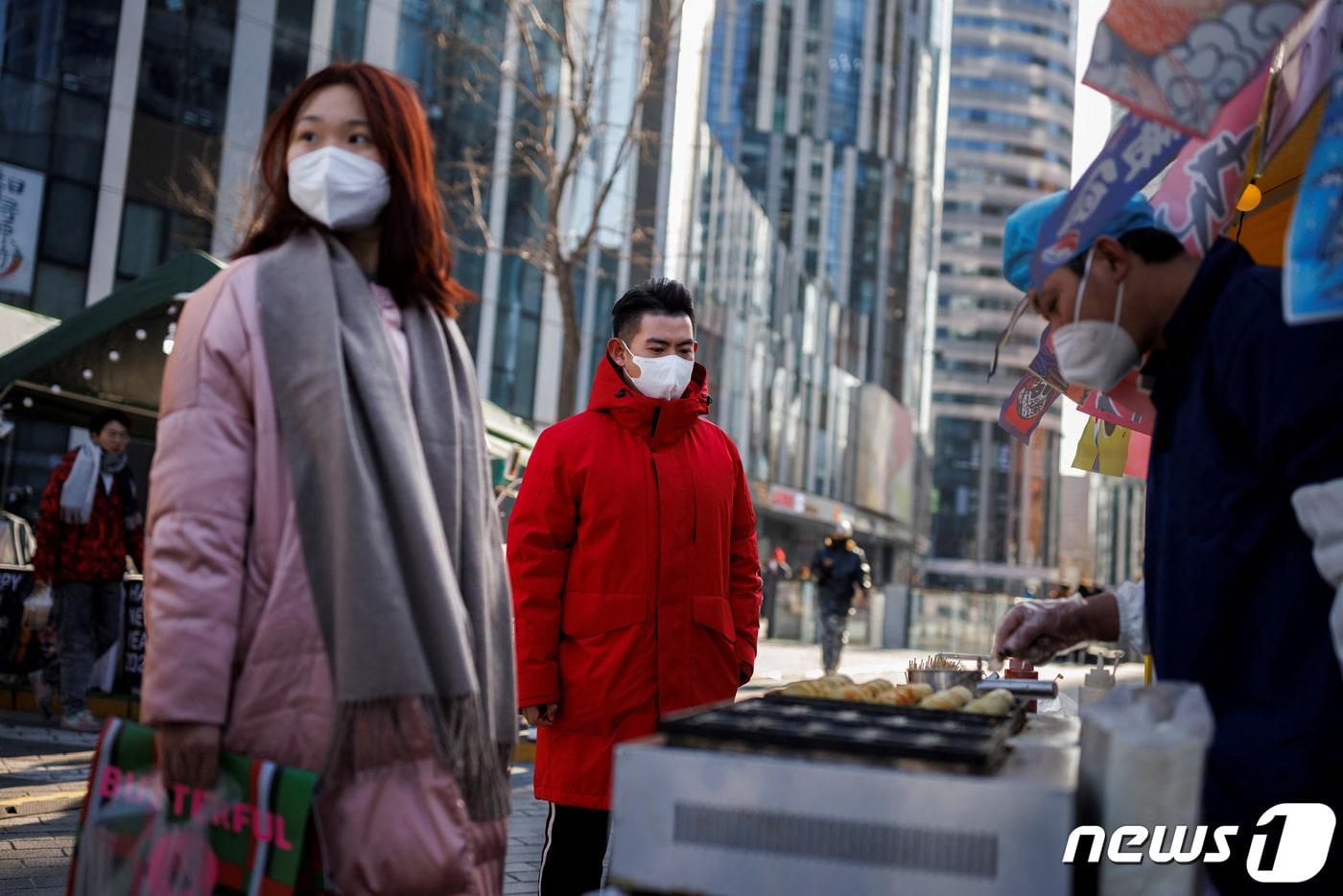 3일&#40;현지시간&#41; 코로나19 확산 속 중국 베이징의 쇼핑 지구에서 주민이 노점 음식을 사고 있다. ⓒ 로이터=뉴스1 ⓒ News1 우동명 기자