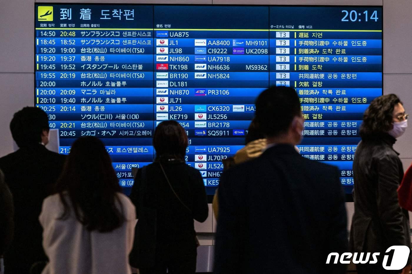 지난달 28일 도쿄 하네다 공항 이용객들이 국제선 항공편의 시간표를 확인하고 있다. ⓒ AFP=뉴스1 ⓒ News1 강민경 기자