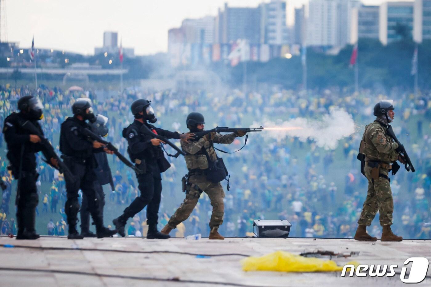 8일&#40;현지시간&#41; 브라질 브라질리아 의회 의사당 앞에서 자이르 보우소나루 전 브라질 대통령 지지자들이 지난 1일 임기를 시작한 루이스 이나시우 룰라 다 시우바 대통령에 반대하는 &#39;대선 불복&#39; 시위를 벌이는 가운데 현지 군경이 의회 습격을 시도하는 이들을 통제하고 있다. 2023.1.8. ⓒ 로이터=뉴스1 ⓒ News1 김성식 기자