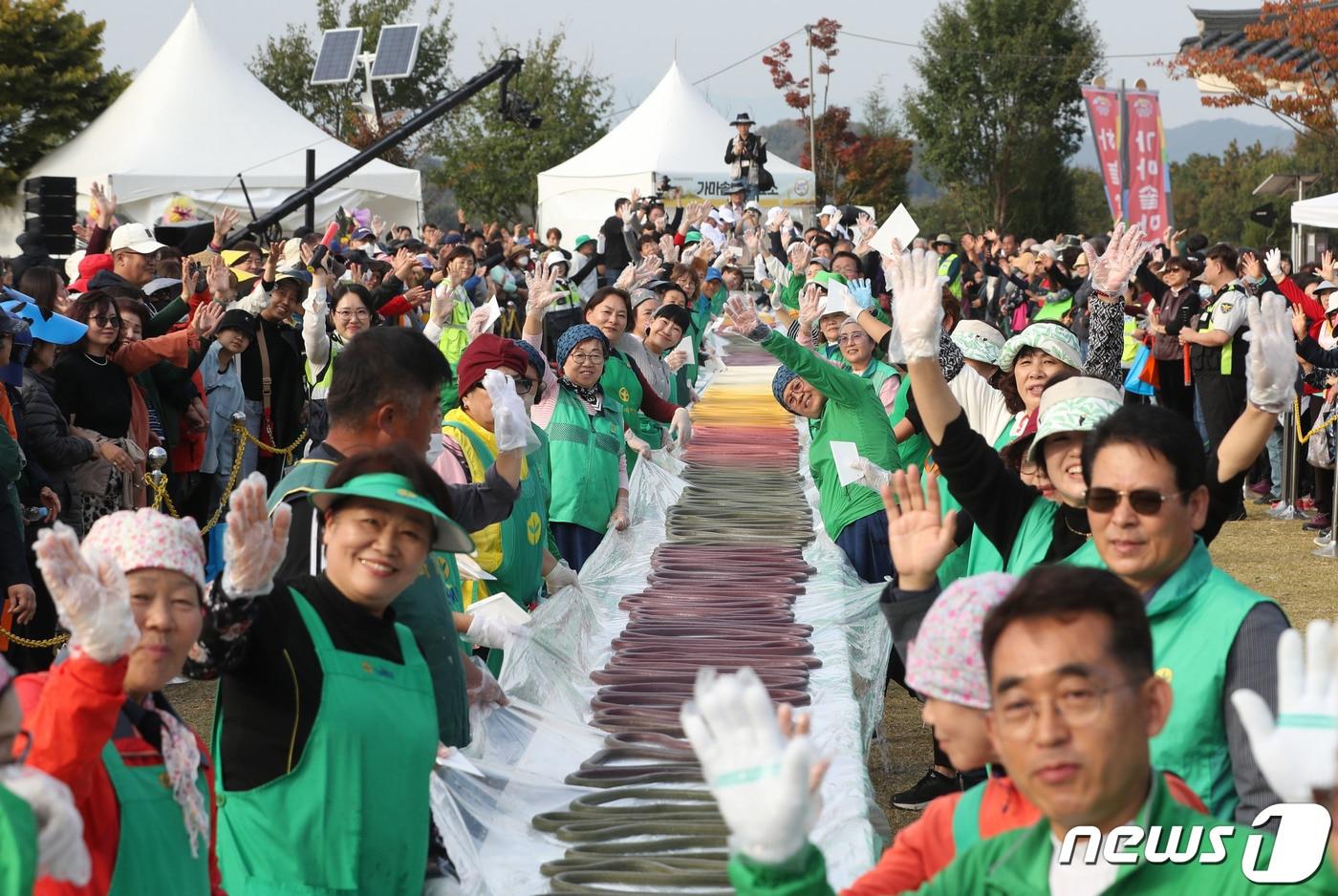 ‘제22회 이천쌀문화축제’가 개막한 18일 오후 경기 이천시 모가면 이천농업테마공원에서 행사 관계자들이 600m 가래떡을 만들고 기념촬영을 하고 있다. 2023.10.18/뉴스1 ⓒ News1 김영운 기자