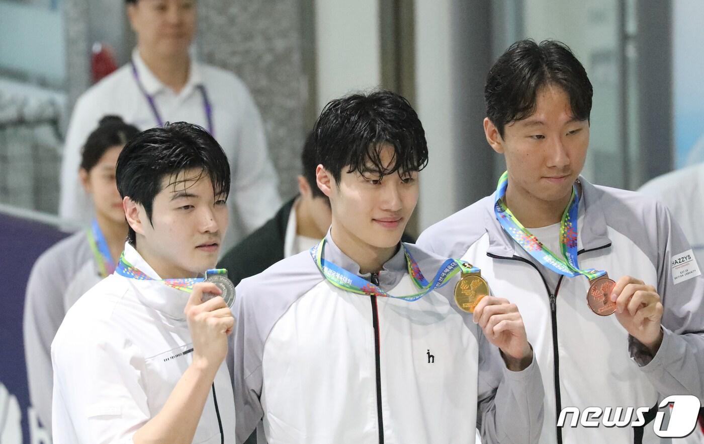 황선우&#40;강원도&#41;가 18일 전남 목포실내수영장 열린 제104회 전국체육대회 수영 남자일반부 100m 결승에서 우승을 차지, 금메달을 목에 걸고 김진원&#40;대구시청, 2위&#41;, 김민준&#40;강원도, 3위&#41;과 함께 시상대에서 포즈를 취하고 있다. 2023.10.18/뉴스1 ⓒ News1 김태성 기자