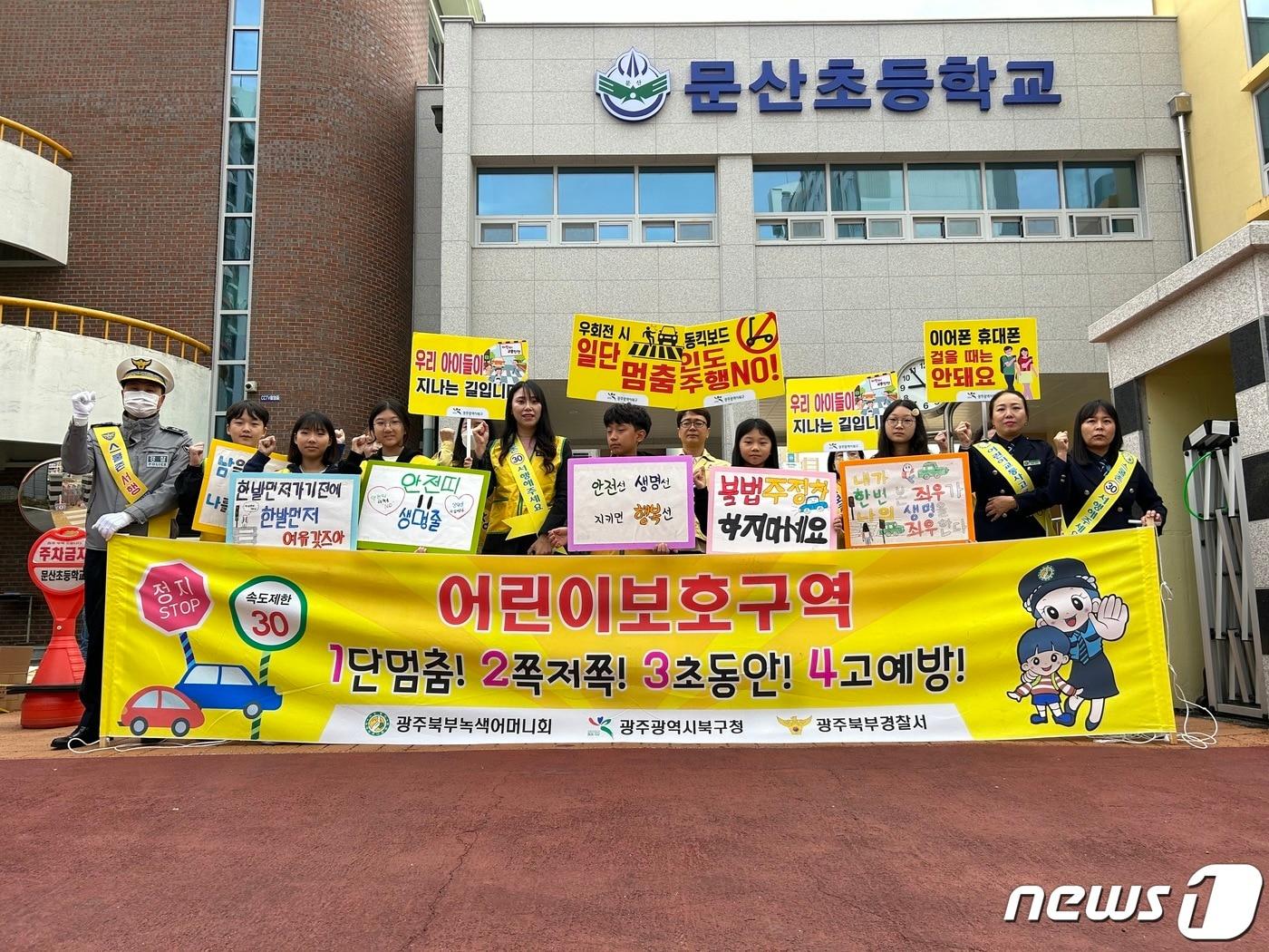 광주 북부경찰서 교통과가 19일 문흥동 문산초등학교 정문과 횡단보도 앞에서 등굣길 어린이 교통안전 캠페인을 실시한 뒤 기념촬영하고 있다. &#40;광주 북부경찰서 제공&#41; 2023.10.19/뉴스1