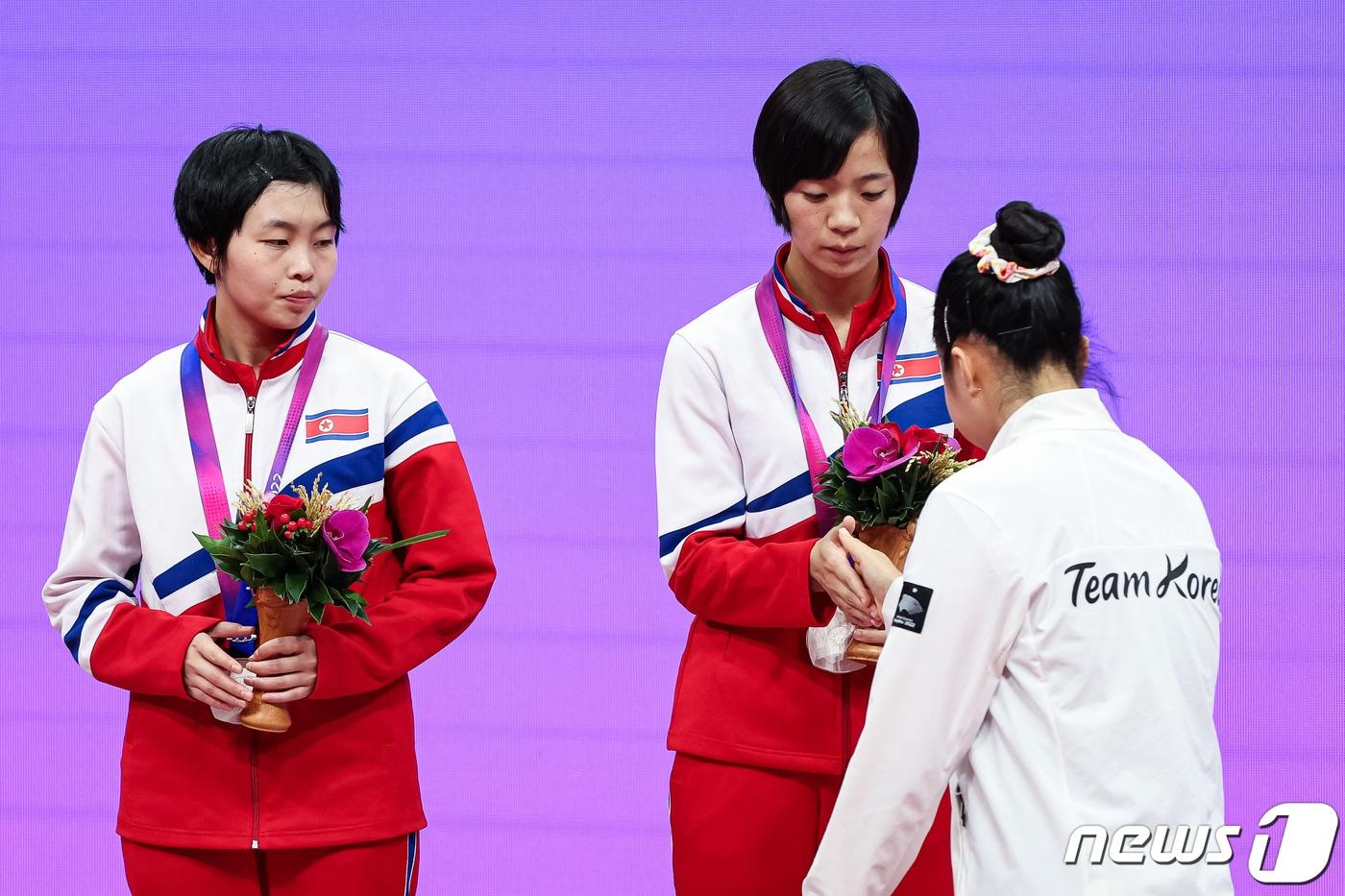 신유빈이 2일 중국 항저우 궁수 캐널 스포츠파크 체육관에서 열린 2022 항저우 아시안게임 탁구 여자 복식 시상식에서 시상대에 오르며 북한 차수영-박수경과 악수하고 있다. 신유빈-전지희 조는 결승에서 북한 차수영-박수경 조를 게임 스코어 4-1&#40;11-6 11-4 10-12 12-10 11-3&#41;로 꺾고 금메달을 차지했다. 이는 2002년 부산 아시안게임 석은미-이은실 이후 21년 만의 아시안게임 여자 복식 금메달이다. 2023.10.2/뉴스1 ⓒ News1 유승관 기자