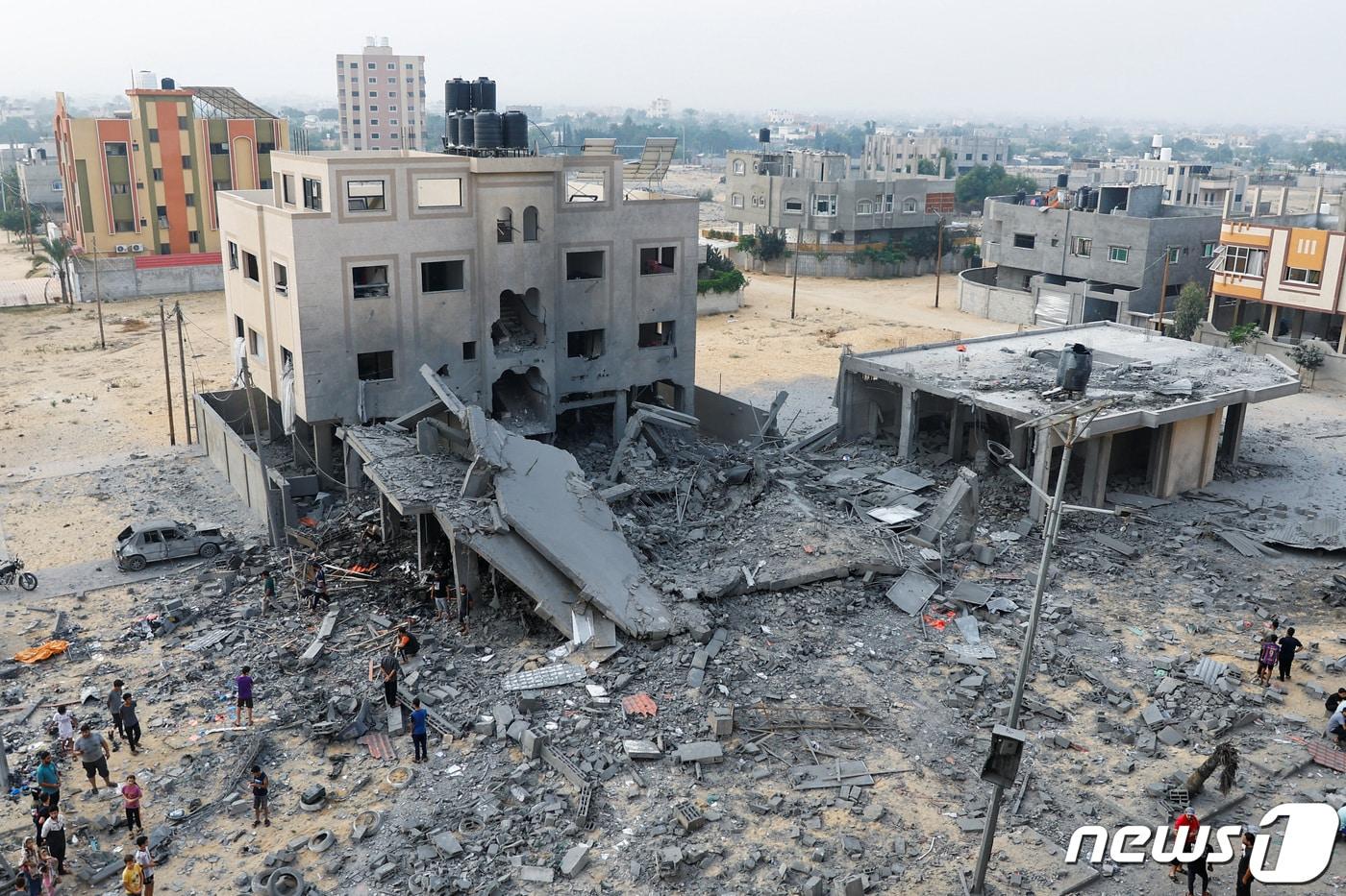 23일&#40;현지시간&#41; 팔레스타인 가자 지구 서부 칸 유니스 지역에서 이스라엘의 폭격으로 인해 무너진 건물 주변에 사람들이 모여있다. 2023.10.23 ⓒ 로이터=뉴스1 ⓒ News1 정지윤 기자