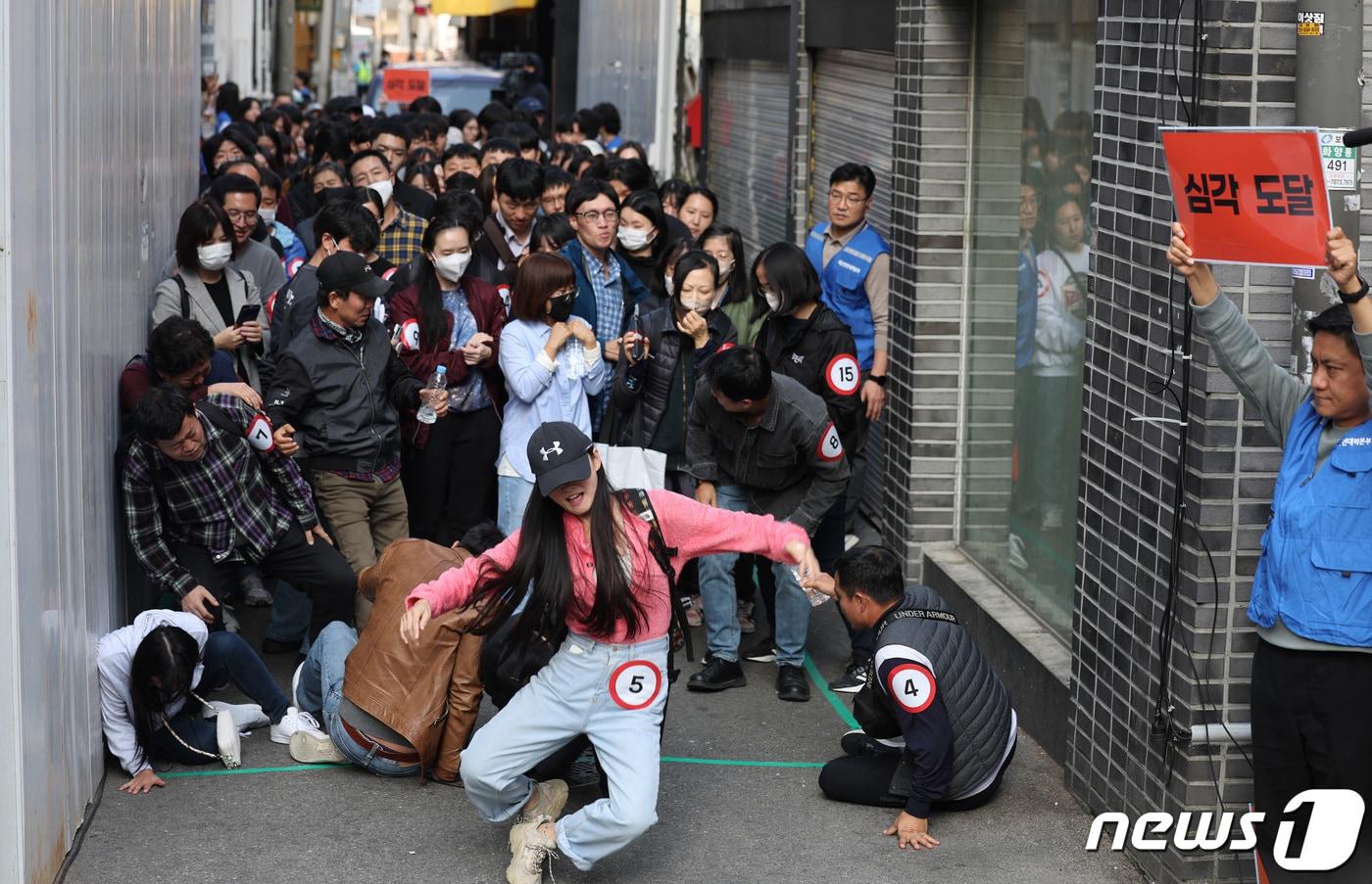 이태원 핼러윈 참사 1주기를 앞둔 25일 서울 광진구 건대맛의거리에서 시민들이 서울시가 새로 도입한 인파감지시스템 활용 유관기관 합동 다중운집 대응 훈련을 하고 있다.  2023.10.25/뉴스1 ⓒ News1 박지혜 기자