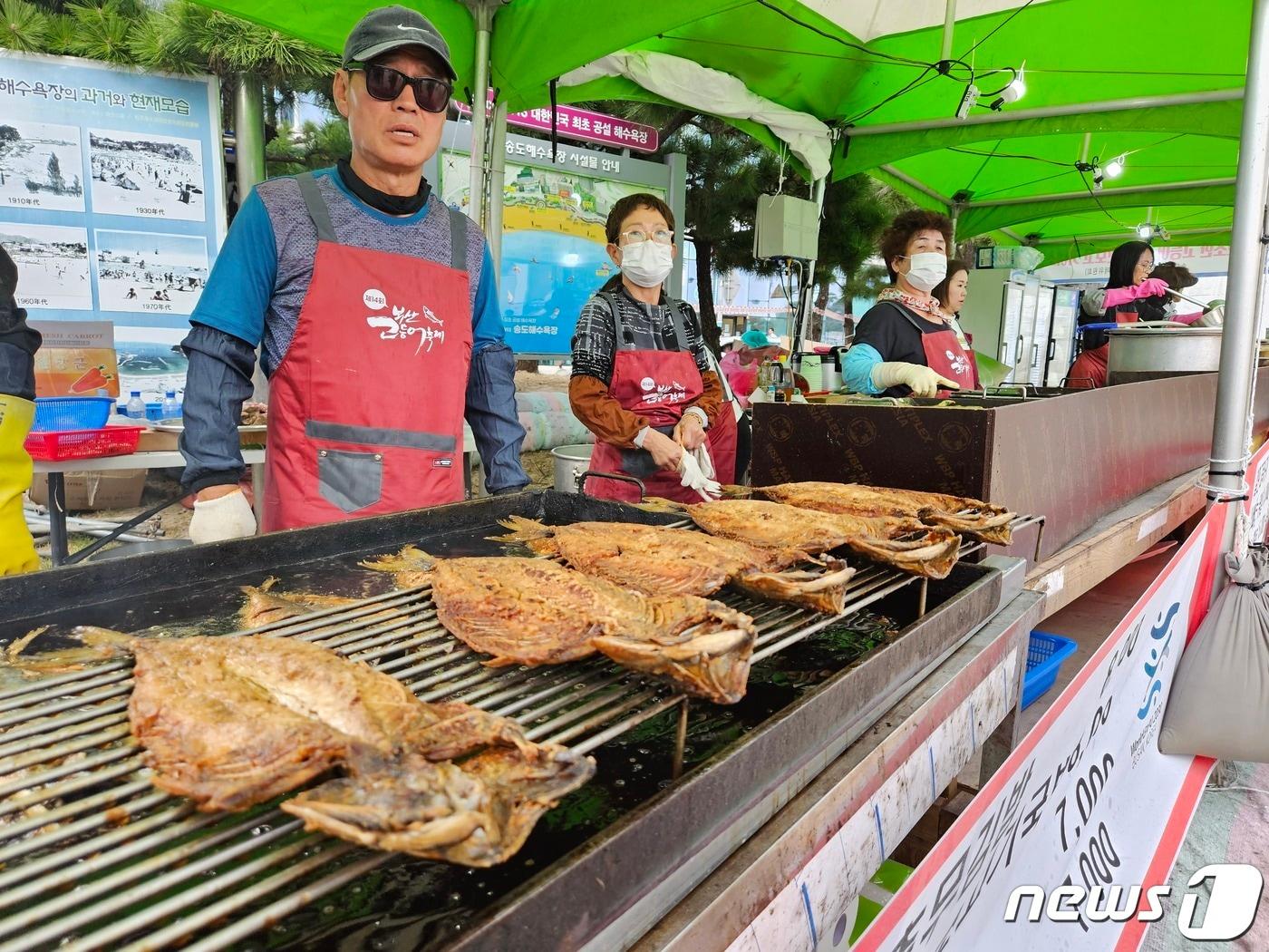 부산 서구 송도해수욕장에서 열린 고등어축제. 상인이 뜨거운 기름으로 구워진 고등어를 팔고 있다. 2023.10.27/뉴스1 ⓒ News1 권영지 기자