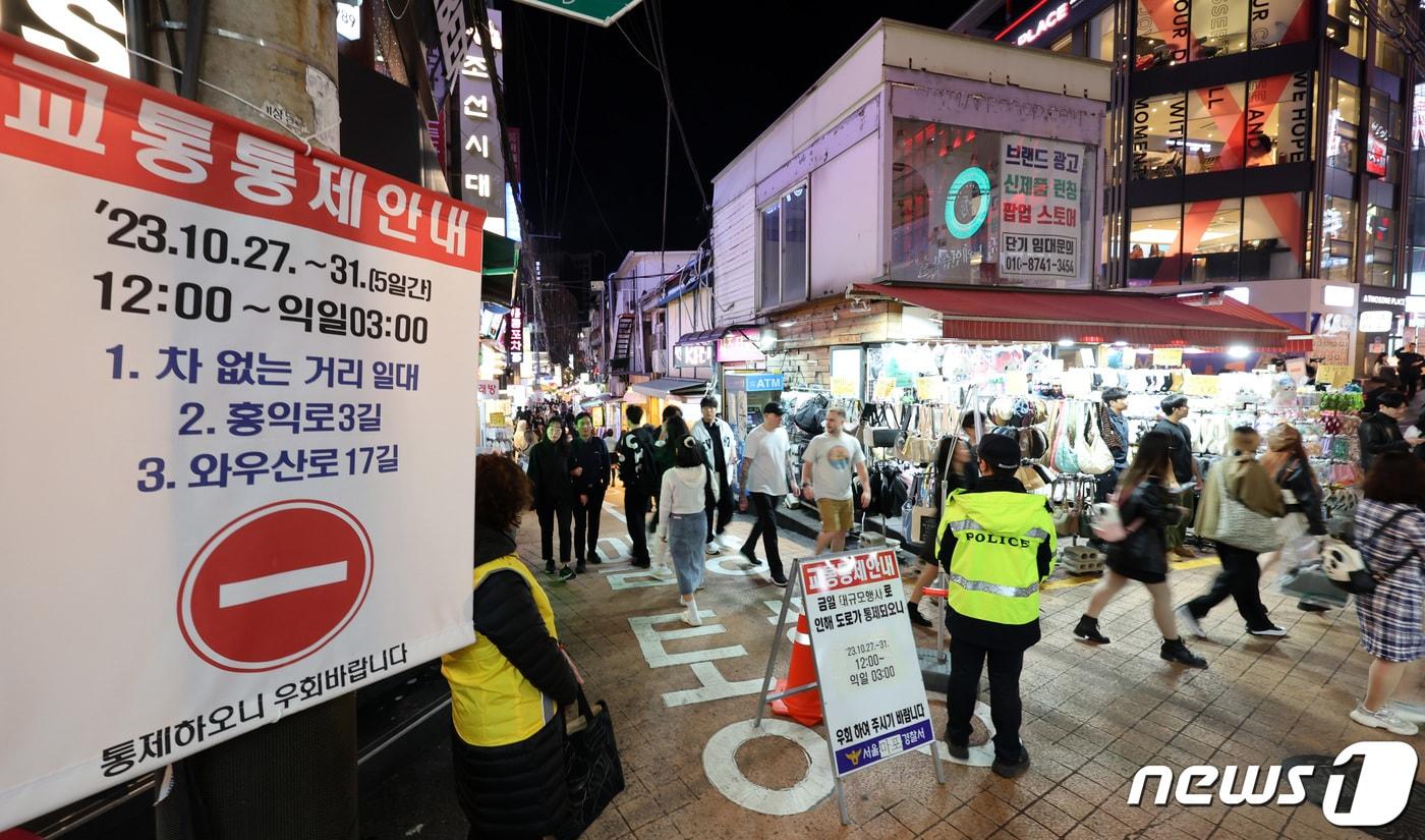 핼러윈 데이를 앞둔 27일 서울 마포구 홍대거리에서 경찰관들이 시민 통행로를 안내하고 있다. 정부는 핼러윈 기간 인파 밀집 위험도가 높을 것으로 예상되는 서울 이태원과 홍대, 명동, 대구 동성로 등 4곳을 집중적으로 관리하기로 했다. 특히 31일 핼러윈 데이에 앞선 주말인 28~29일에 주요 번화가에 인파가 몰릴 것으로 관측돼 용산구 등 서울 자치구들이 선제 대응에 나섰다. 2023.10.27/뉴스1 ⓒ News1 김성진 기자