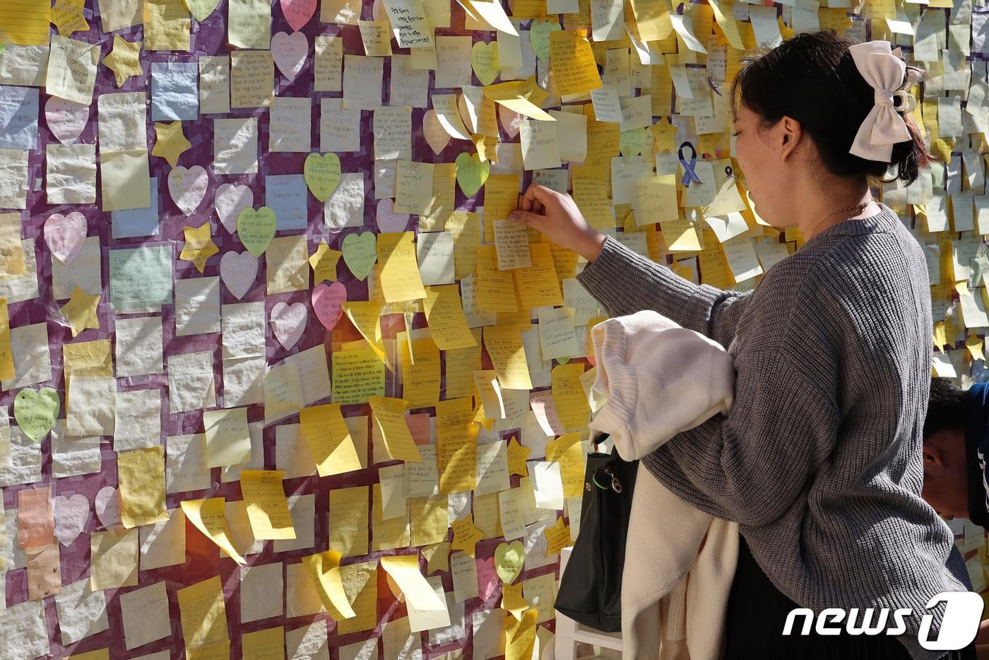 10.29 이태원 참사 1주기인 29일 오후 서울 용산구 이태원 거리에 마련된 추모공간에서 유가족이 추모 메시지를 붙이고 있다. 2023.10.29/뉴스1 ⓒ News1 이동해 기자