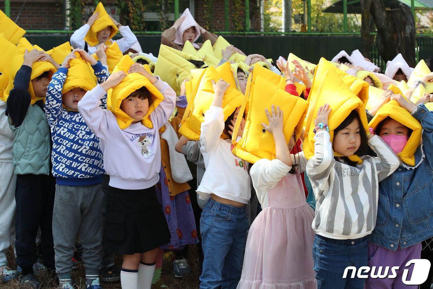 30일 대구 수성구 황금유치원에서 &#39;2023년 재난대응 안전한국훈련&#39;의 일환으로 열린 지진 대피 훈련에 참여한 어린이들이 지진경보가 울리자 지진방재모자로 머리를 보호하며 지도교사의 안내에 따라 신속히 대피하고 있다. 2023.10.30/뉴스1 ⓒ News1 공정식 기자