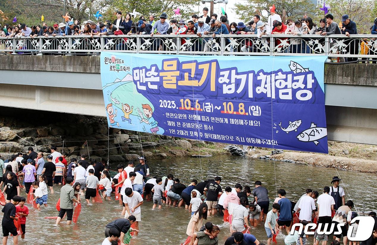 지난해 제11회 완주와일드&로컬푸드축제에서 방문객들이 맨손물고기잡기 체험을 하고 있다./뉴스1