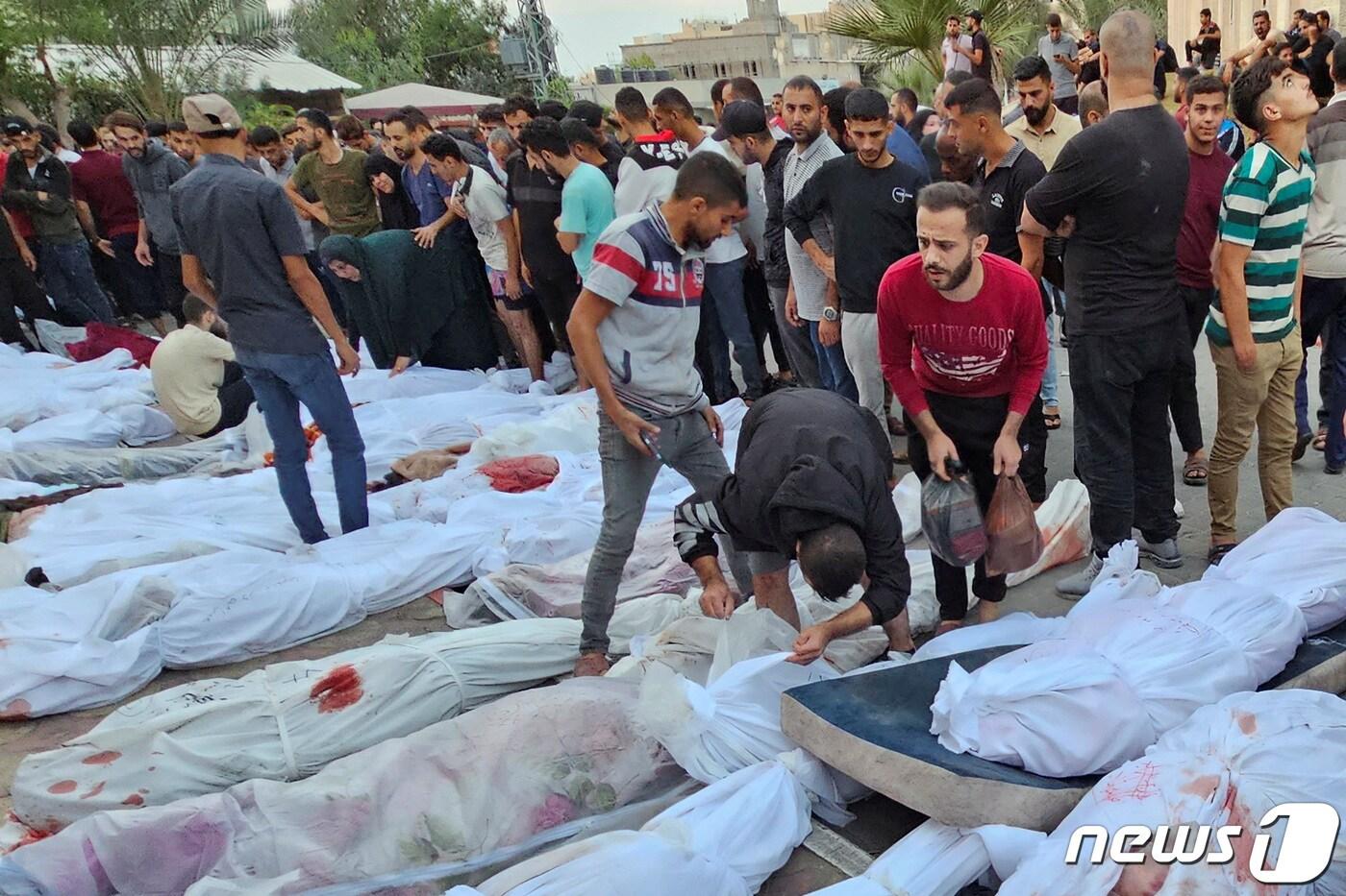 31일&#40;현지시간&#41; 팔레스타인 가자 지구 난민촌 주민들이 사망자의 시신을 확인하고 있다. ⓒ 로이터=뉴스1 ⓒ News1 박형기 기자