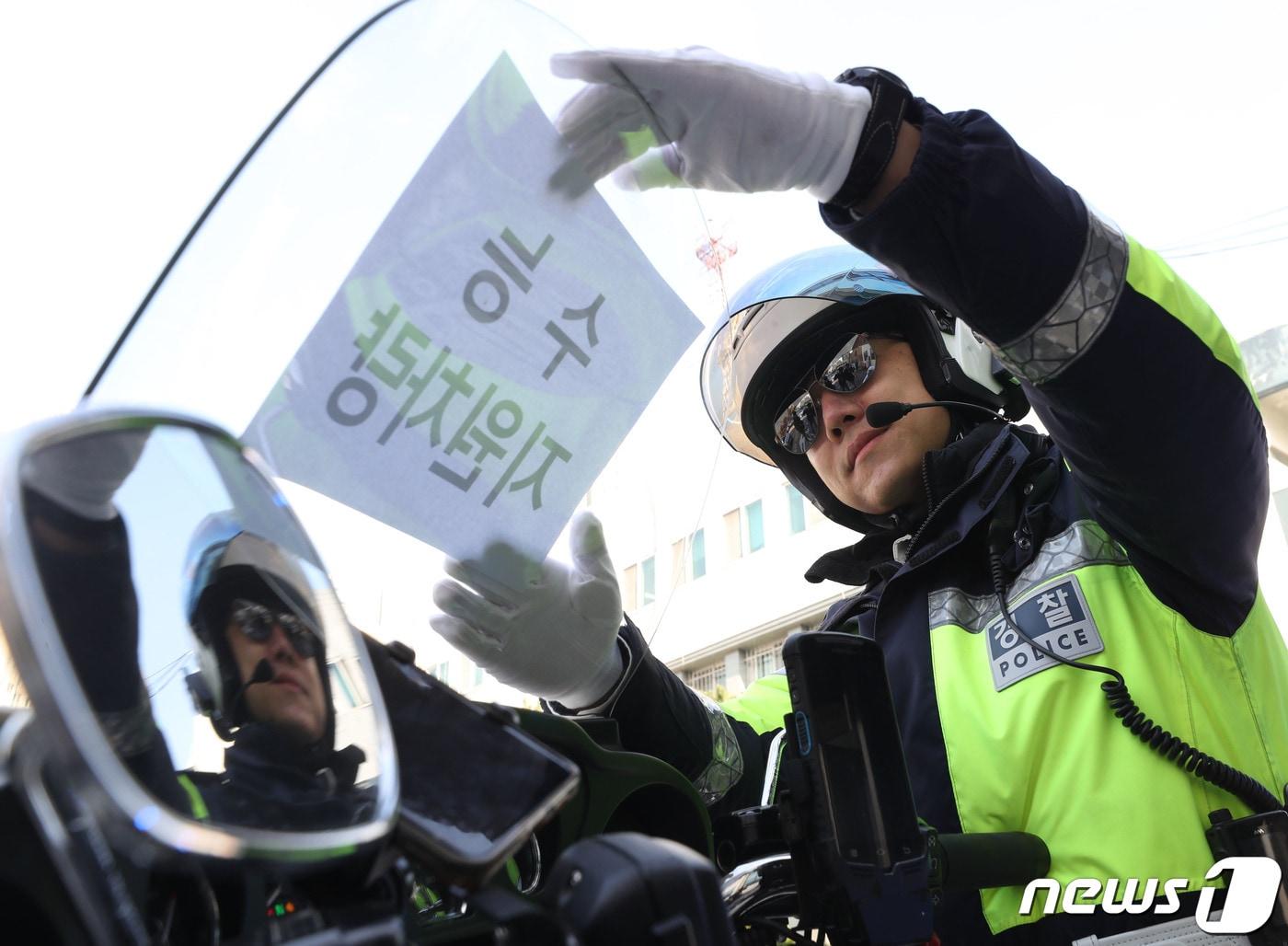 2024학년도 대학수학능력시험을 이틀 앞둔 14일 오후 경기 수원시 영통구 수원남부경찰서에서 교통안전계 경찰관들이 수능 당일 시험장 주변 특별 교통관리에 투입될 지원차량에 안내문을 부착하고 있다. 2023.11.14/뉴스1 ⓒ News1 김영운 기자