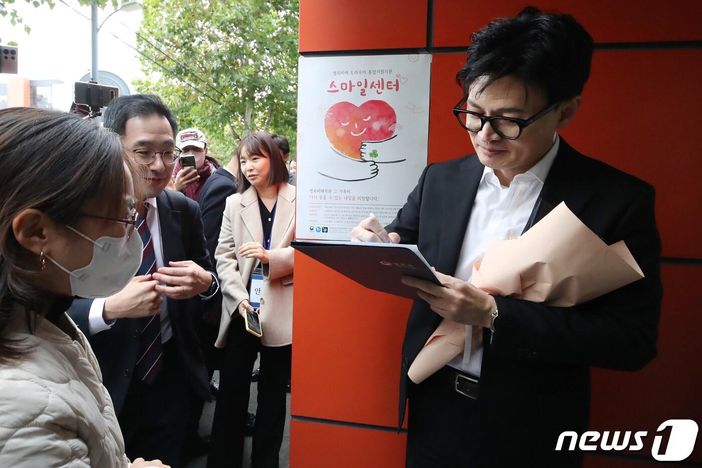 한동훈 법무부 장관이 17일 오후 대구 수성구 만촌동 대구스마일센터를 찾아 직원 간담회를 마치고 입구에서 기다리던 시민들에게 사인을 해주고 있다. 2023.11.17/뉴스1 ⓒ News1 공정식 기자