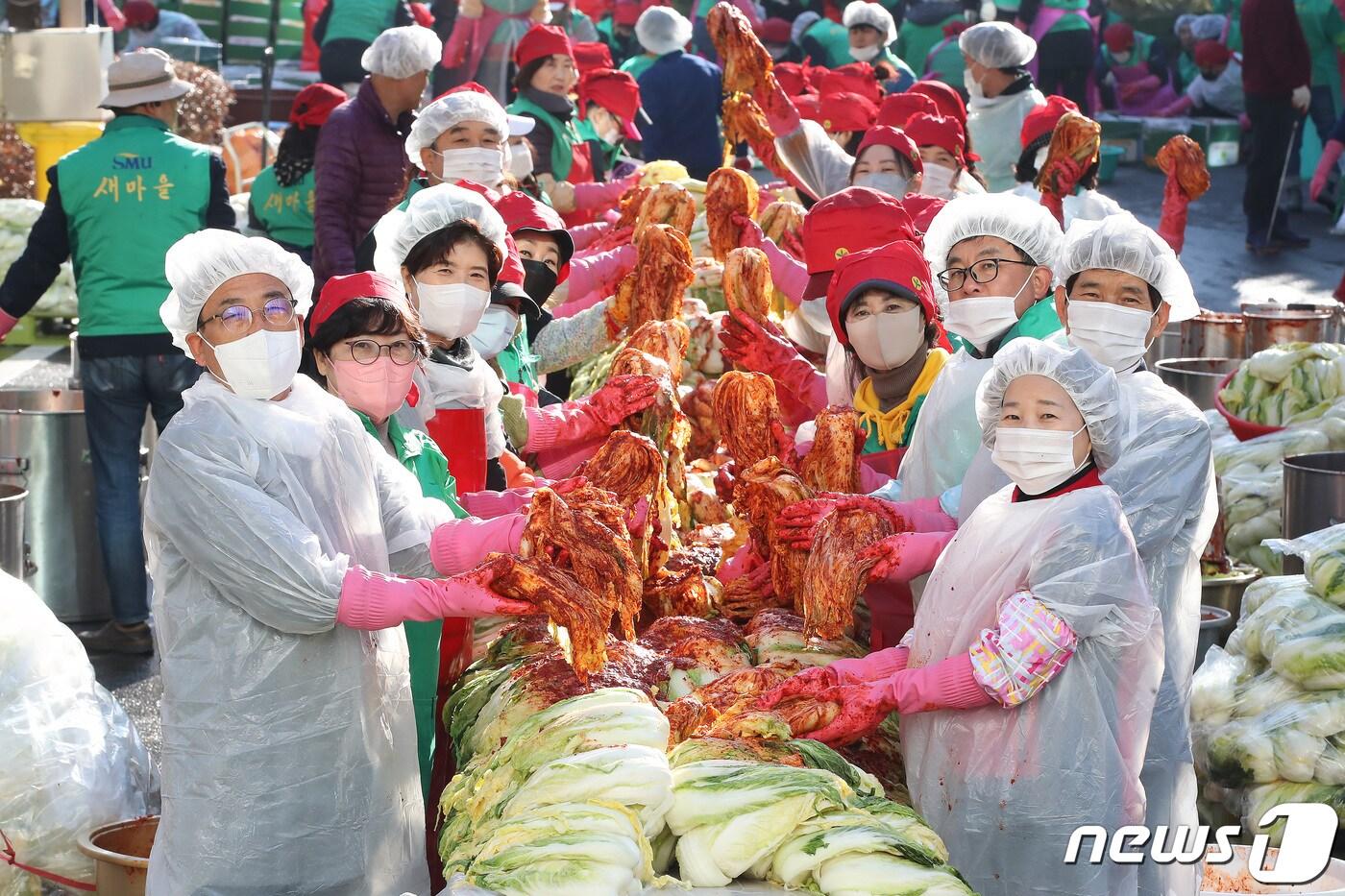 대구 달서구보건소 주차장에서 열린 &#39;달서구새마을회 2023년 사랑의 김장 나누기&#39; 행사에 참여한 새마을협의회·부녀회와 다문화여성 등 봉사자들이 양념을 버무린 배추를 들어 보이고 있다. 2023.11.21/뉴스1 ⓒ News1 공정식 기자