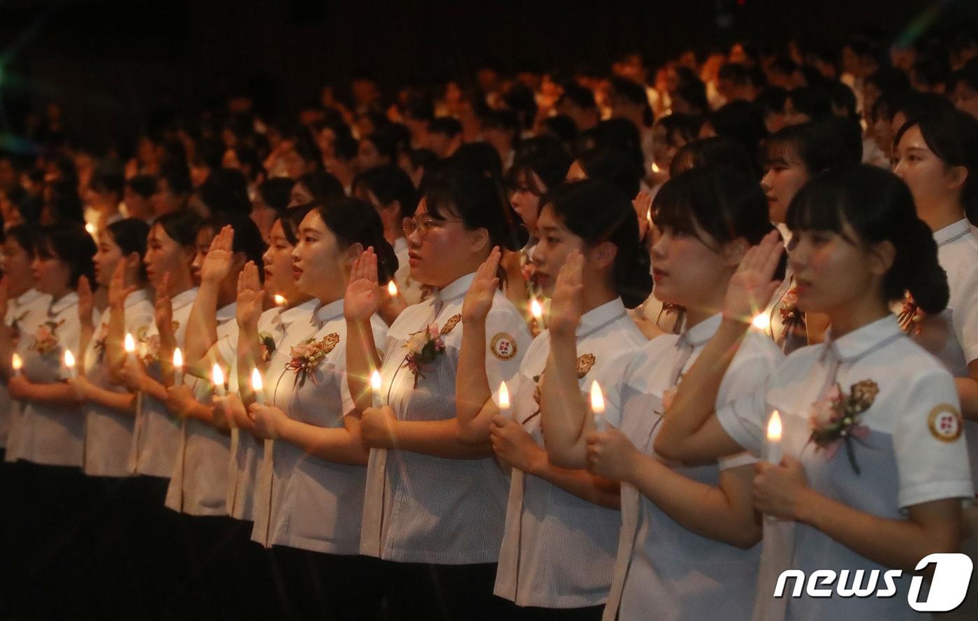 23일 오전 대구 북구 태전동 대구보건대 인당아트홀에서 열린 제25회 나이팅게일 선서식에서 임상 실습을 앞둔 간호학과 학생들이 LED 촛불을 밝혀 나이팅게일의 숭고한 희생정신을 본받을 것을 다짐하고 있다. 2023.11.23/뉴스1 ⓒ News1 공정식 기자