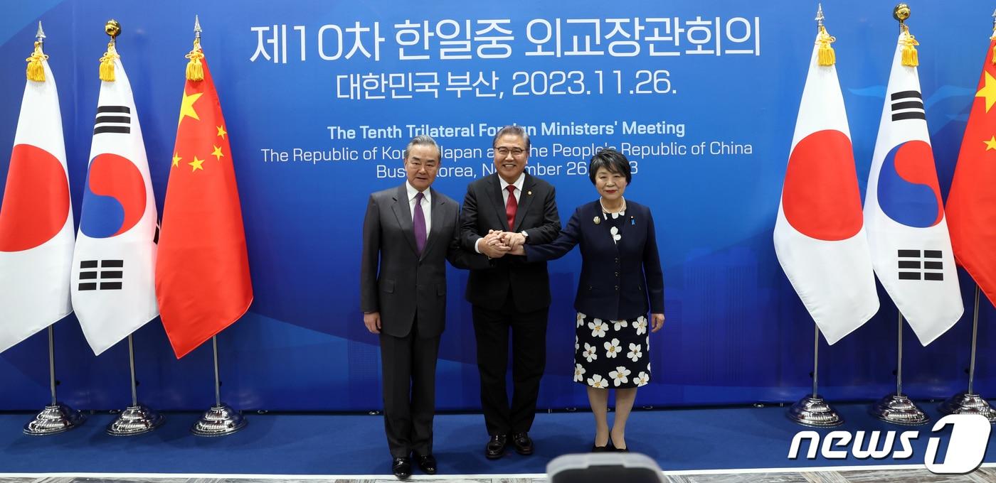 박진&#40;가운데&#41; 외교부 장관, 가미카와 요코&#40;오른쪽&#41; 일본 외무상, 왕이 중국 외교부장이 26일 오후 부산 해운대구 시그니엘 부산에서 열린 한일중 외교장관 회의에서 손을 맞잡고 기념촬영을 하고 있다. 2023.11.26/뉴스1 ⓒ News1 김명섭 기자