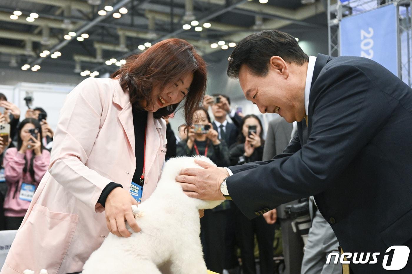 윤석열 대통령이 3일 경기 고양시 일산서구 킨텍스에서 열린 2023 대한민국 소상공인대회 펫산업연합회 부스를 찾아 강아지를 쓰다듬고 있다. &#40;대통령실 제공&#41; 2023.11.3/뉴스1 ⓒ News1 안은나 기자