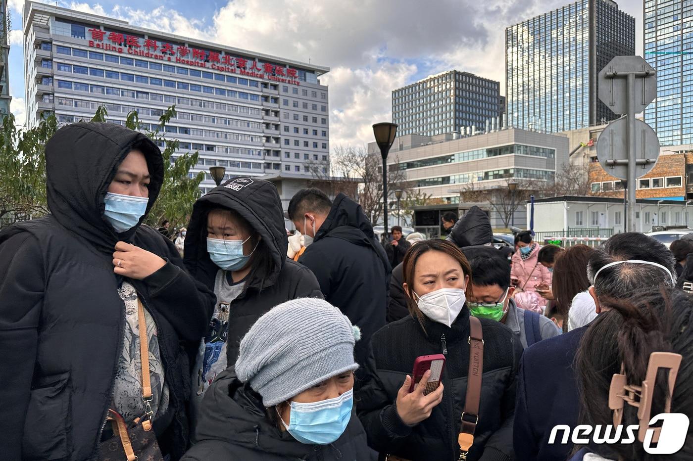 사람들이 중국 베이징의 한 어린이병원 앞에서 차를 기다리고 있다. 2023.11.27. ⓒ 로이터=뉴스1