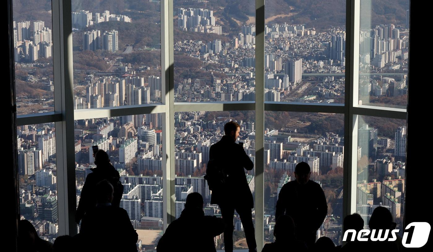 30일 오후 서울 송파구 롯데월드타워 전망대를 찾은 관람객이 아파트 단지를 바라보고 있다.2023.11.30/뉴스1 ⓒ News1 장수영 기자