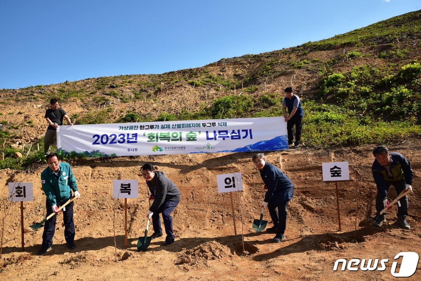 경북 울진군 북면 나곡리 산불피해지 일대에서 남태헌&#40;앞줄 오른쪽 두 번째&#41; 한국산림복지진흥원장을 비롯한 두나무, 울진군 등 기관 관계자들이 기념식수를 심고 있다.