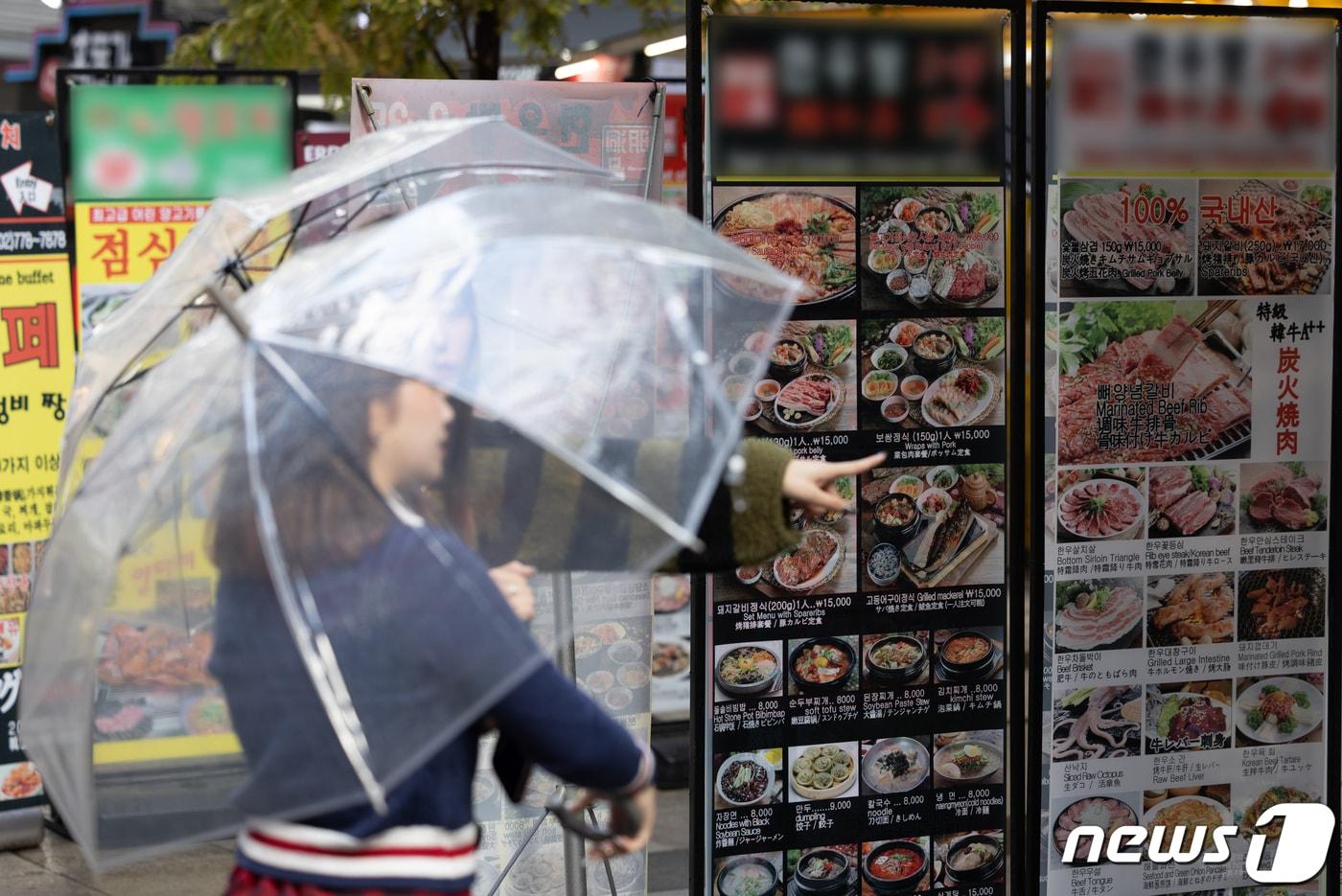 먹거리 물가가 3년 연속 5% 넘게 오르고 있는 6일 서울 중구 명동거리 음식점 메뉴판 앞으로 외국인 관광객들이 지나가고 있다. 2023.11.6/뉴스1 ⓒ News1 이재명 기자