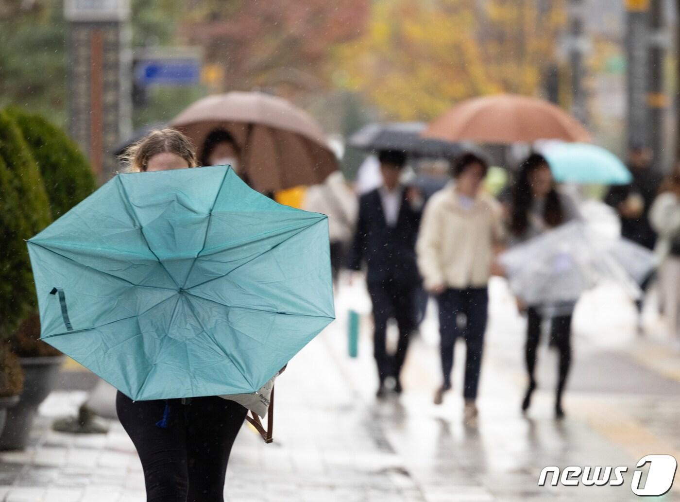 서울 지역에 강풍주의보가 발령된 6일 오후 서울 세종대로의 거리에서 한 시민이 바람에 뒤집힌 우산을 정돈하고 있다. 2023.11.6/뉴스1 ⓒ News1 이재명 기자