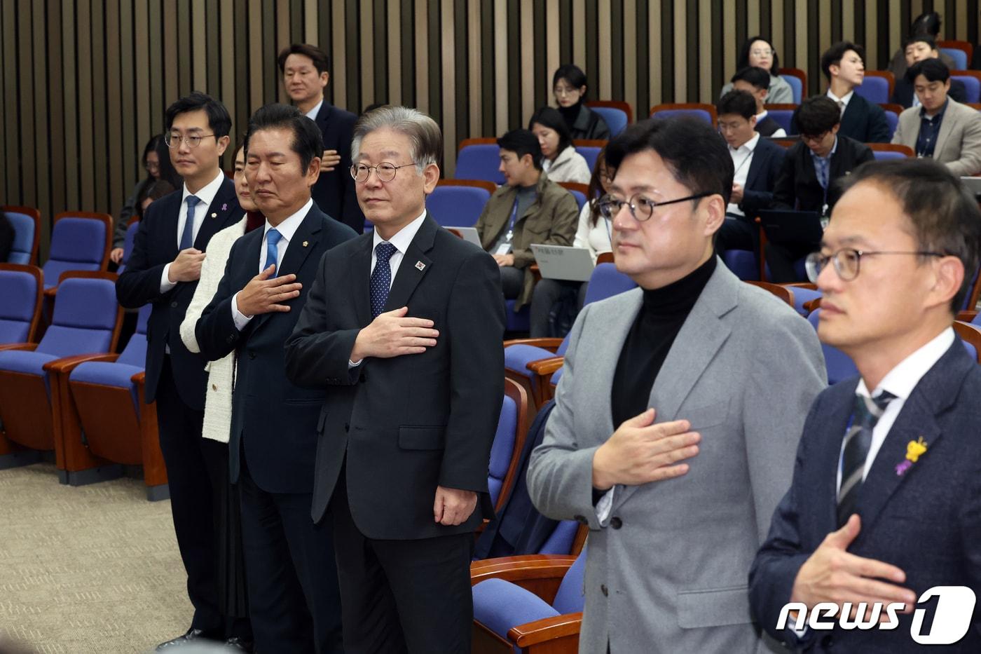 더불어민주당 이재명 대표와 홍익표 원내대표가 8일 오후 서울 여의도 국회에서 열린 의원총회에서 의원들과 국민의례를 하고 있다. 2023.11.8/뉴스1 ⓒ News1 황기선 기자