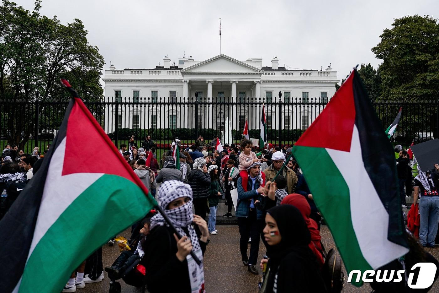 지난달 14일&#40;현지시간&#41; 팔레스타인 깃발을 든 시위대는 미국 워싱턴DC 백악관 앞에서 조 바이든 대통령을 향해 이스라엘 지원을 중단할 것을 요구했다. 2023.10.14. ⓒ 로이터=뉴스1 ⓒ News1 김성식 기자