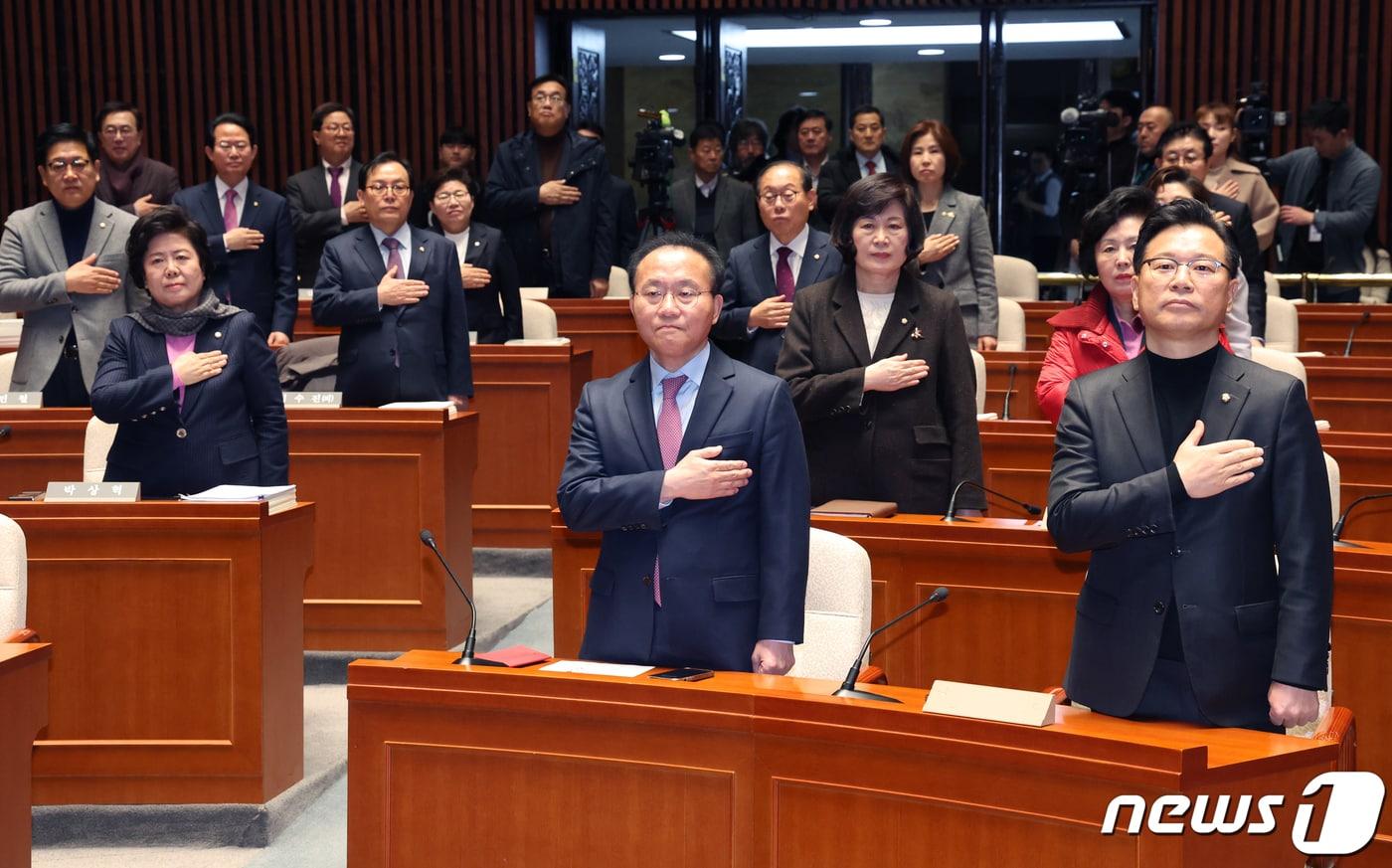 윤재옥 국민의힘 당 대표 권한대행을 비롯한 의원들이 15일 서울 여의도 국회에서 열린 비상의원총회에서 국기에 경례를 하고 있다. 2023.12.15/뉴스1 ⓒ News1 송원영 기자