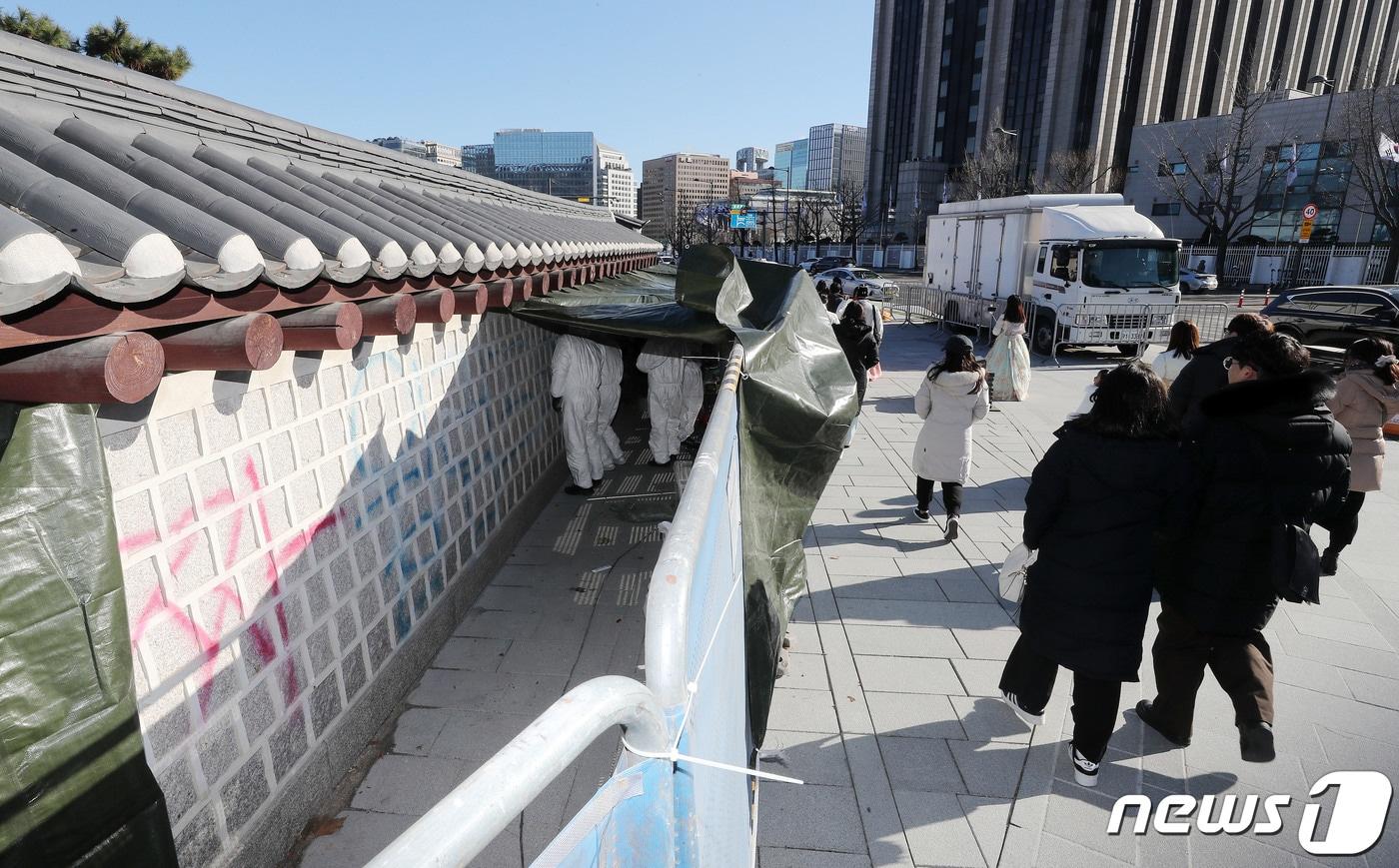 문화재청 관계자들이 17일 오전 서울 종로구 경복궁 서쪽 담장에 새겨진 낙서 제거작업을 하고 있다. 2023.12.17/뉴스1 ⓒ News1 박세연 기자