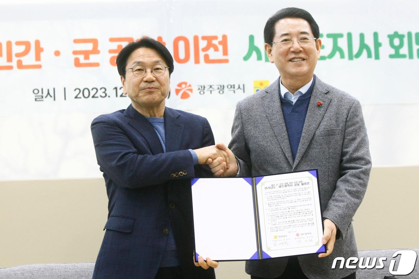 강기정 광주시장&#40;왼쪽&#41;과 김영록 전남지사가 17일 오후 나주 혁신도시 내 한국농수산식품유통공사 회의실에서 광주 군·민간공항 이전과 관련해 공동발표문에 서명 후 악수하고 있다. 2023.12.17/뉴스1 ⓒ News1 김태성 기자