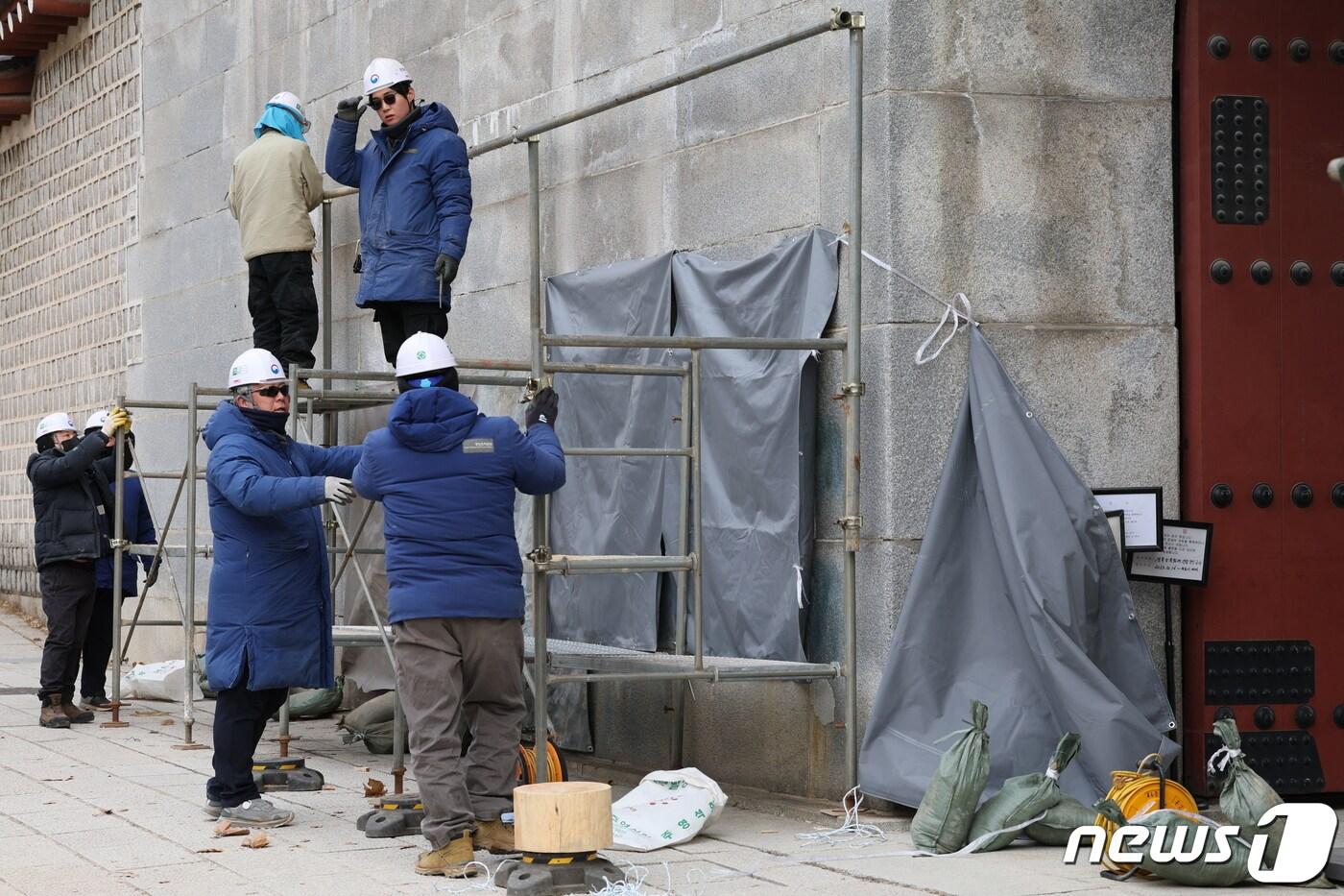 경복궁 담벼락 &#39;낙서 테러&#39;가 이틀째 이어진 18일 오전 서울 종로구 통의동 경복궁 영추문 앞에서 문화재청 관계자들이 복구 작업을 위해 가림막 설치 작업을 하고 있다. 2023.12.18/뉴스1 ⓒ News1 박정호 기자