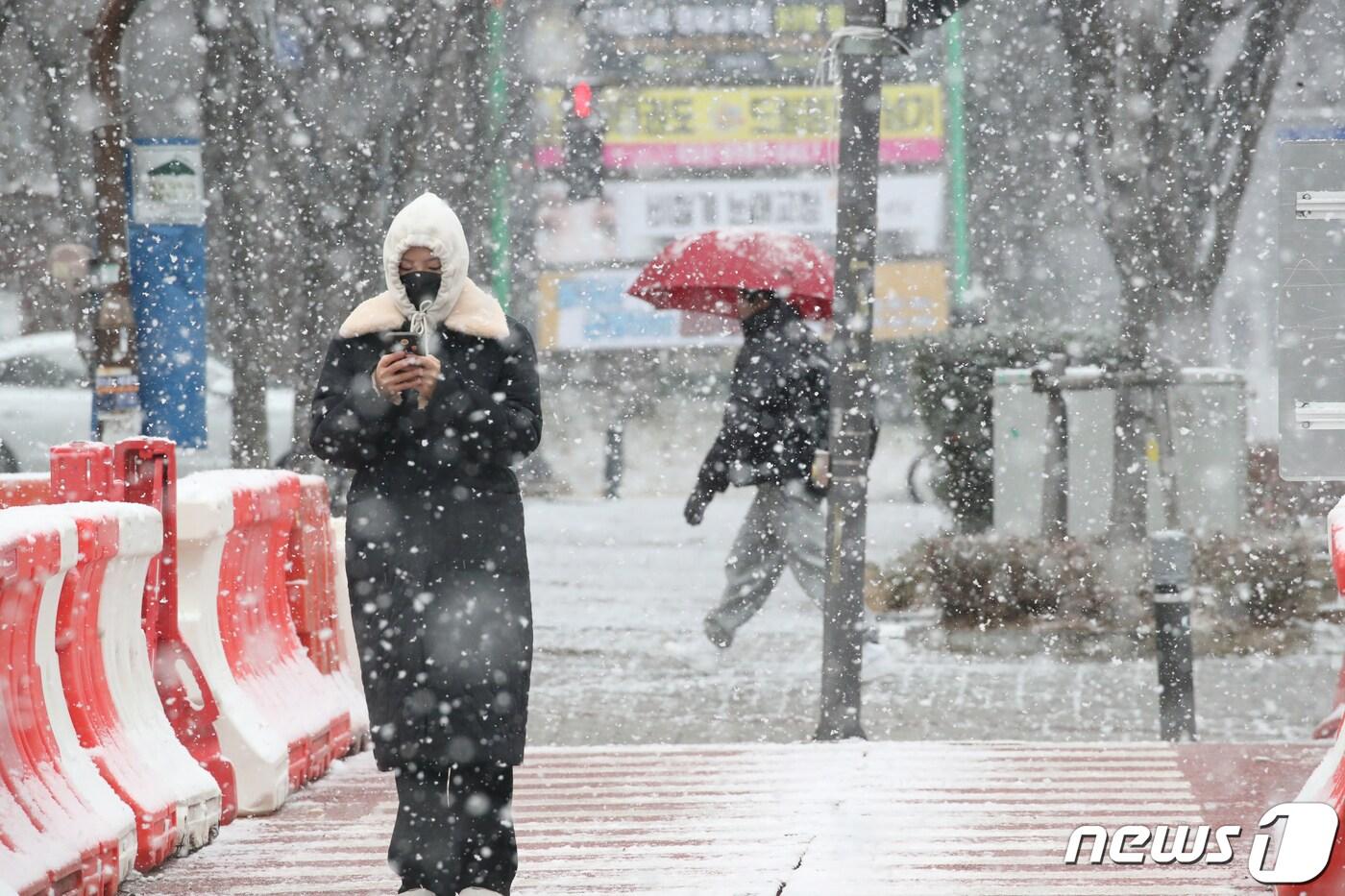 광주와 전남에 많은 눈이 예보된 20일 광주 서구 상무지구에 시민들이 눈을 맞으며 걸어가고 있다.2023.12.20/뉴스1 ⓒ News1 김태성 기자