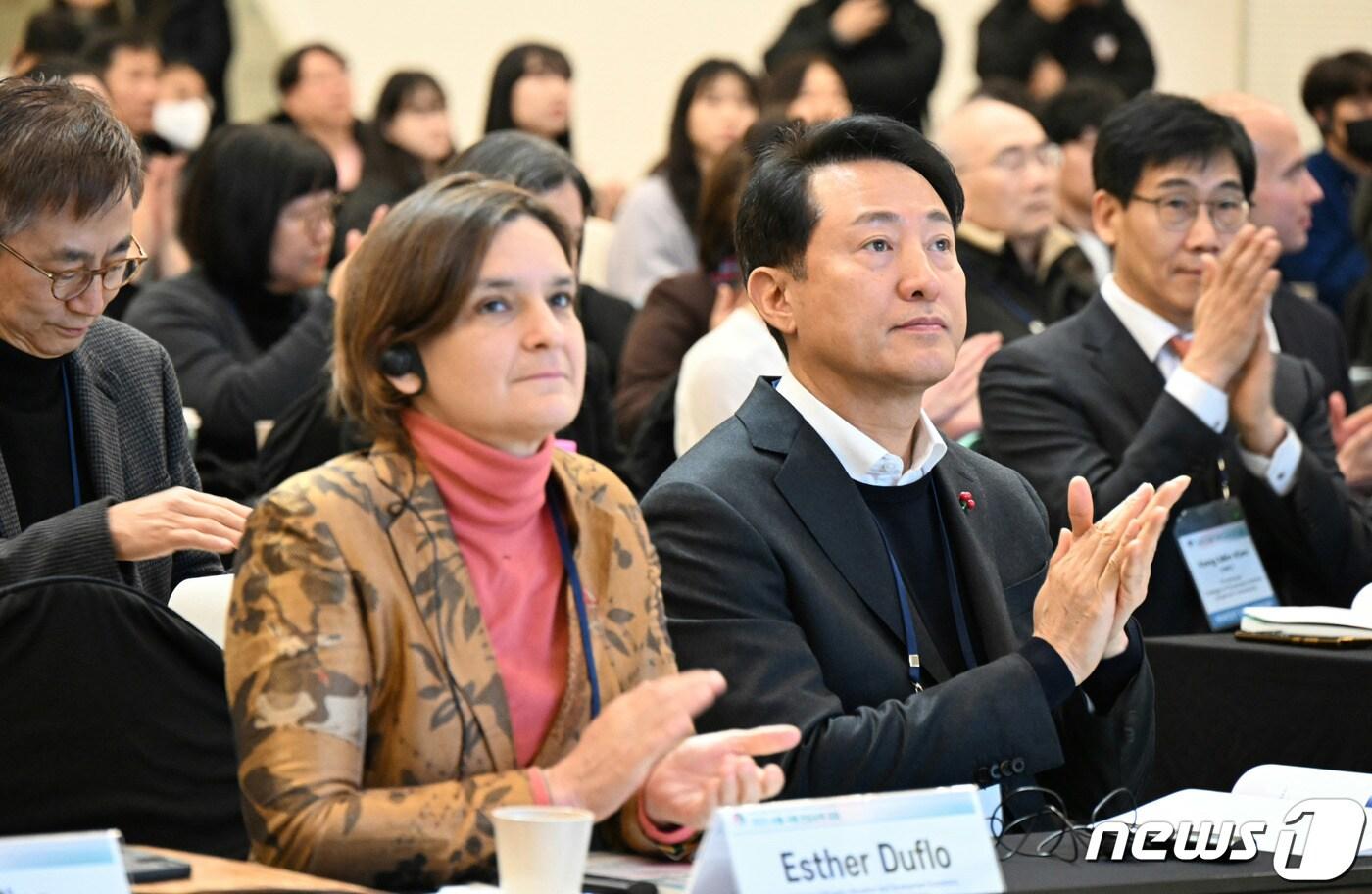 오세훈 서울시장과 2019년 노벨경제학상을 수상한 에스테르 뒤플로 매사추세츠공과대&#40;MIT&#41; 교수가 지난해 12월20일 서울 중구 동대문디자인플라자&#40;DDP&#41;에서 열린 ‘2023 서울 국제 안심소득 포럼’ 개회식에서 박수를 치고 있다. &#40;서울시 제공&#41;