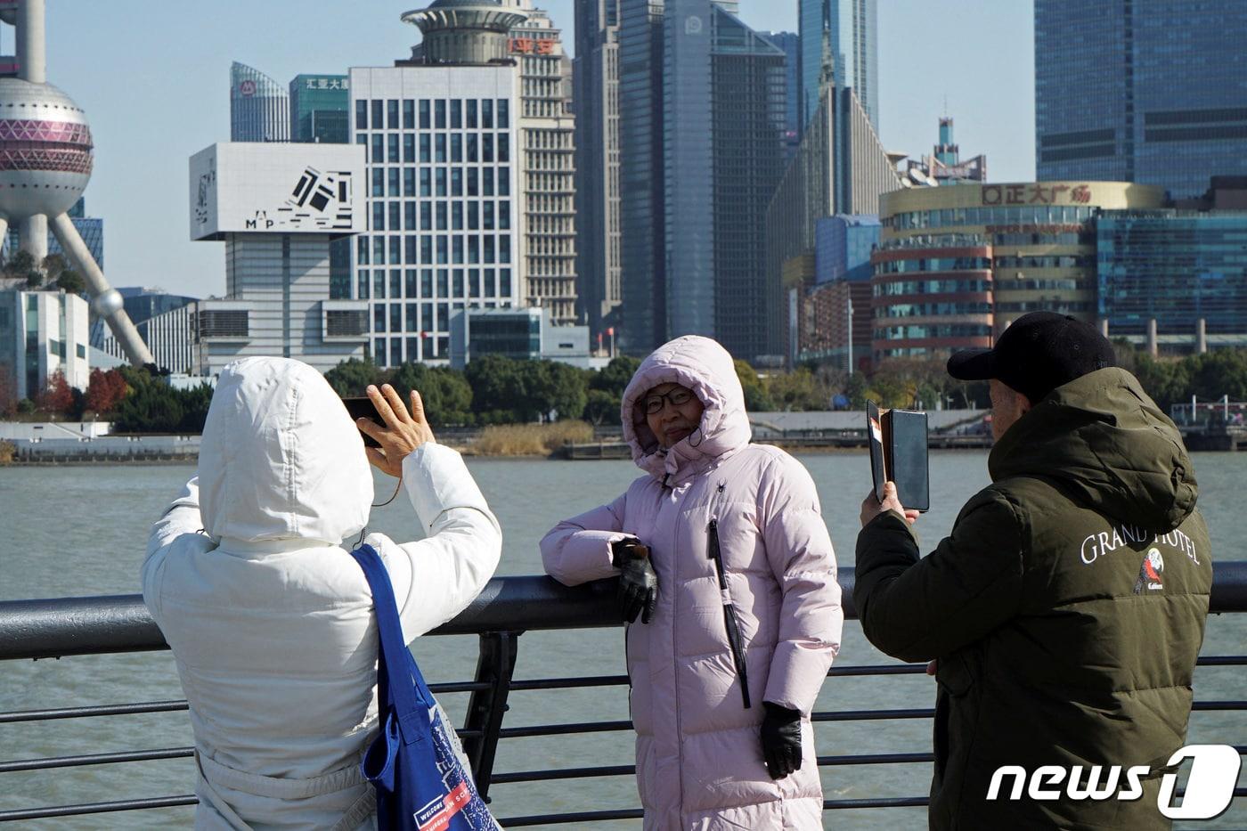 21일 중국 상하이에 맹추위가 찾아오자 행인들이 두꺼운 패딩 재킷을 입고 돌아다니고 있다. 2023.12.21 ⓒ 로이터=뉴스1 ⓒ News1 강민경 기자