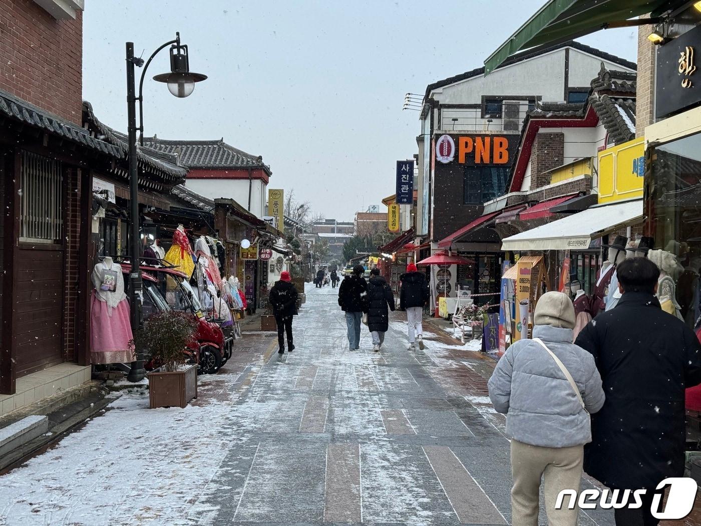 성탄절인 25일 오전 전북 전주시 풍남동 한옥마을에서 관광객들이 눈 덮인 거리를 거닐고 있다..2023.12.25./뉴스1 김경현 수습기자