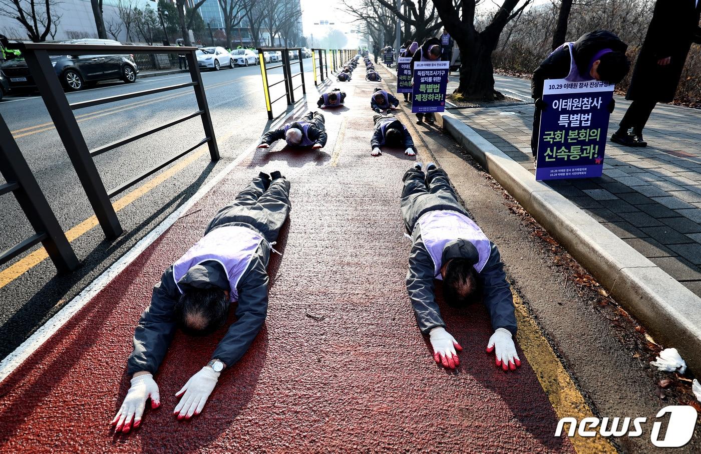 이태원참사 희생자 유가족을 비롯한 10·29이태원참사시민대책위 회원들이 서울 여의도 국회 둘레길에서 이태원 참사 진상규명 특별법 통과를 촉구하며 오체투지 행진을 하고 있다. 2023.12.27/뉴스1 ⓒ News1 구윤성 기자