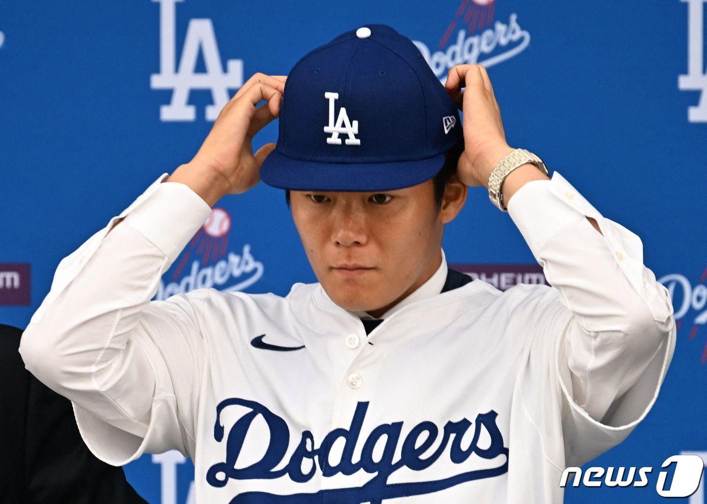 일본인 투수 야마모토 요시노부가 27일&#40;현지시간&#41; 역대 MLB 투수 최고 보장액인 12년 3억2500만 달러를 받고 캘리포니아주 로스앤젤레스 다저스타디움에서 열린 입단식서 다저스 유니폼과 모자를 착용하고 있다. 2023.12.28 ⓒ AFP=뉴스1 ⓒ News1 우동명 기자