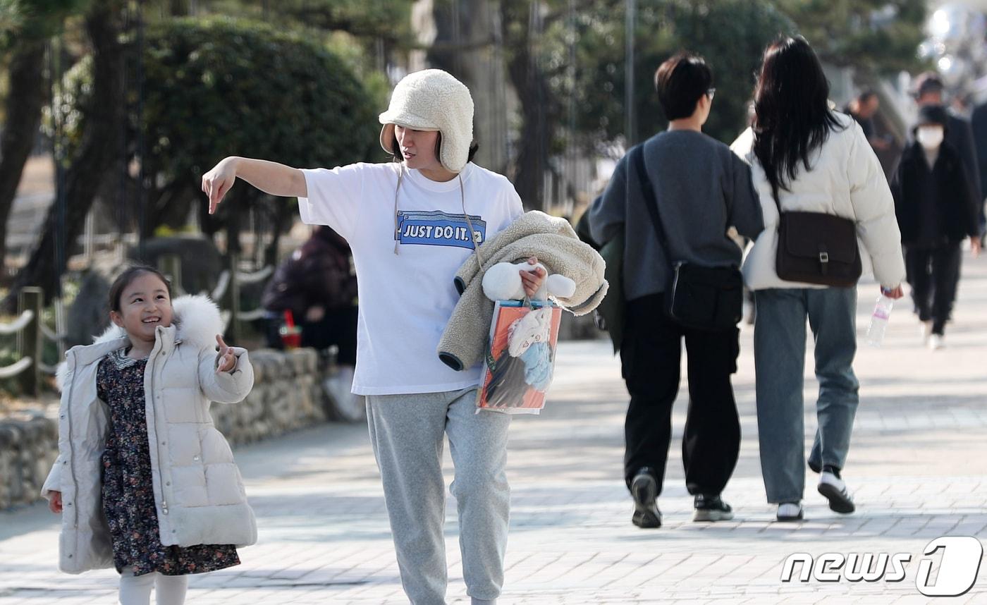 비교적 포근한 날씨가 이어진 28일 오후 부산 광안리해수욕장에서 외투를 팔에 걸고 반팔 차림을 한 시민이 딸과 함께 걷고 있다. 2023.12.28/뉴스1 ⓒ News1 윤일지 기자