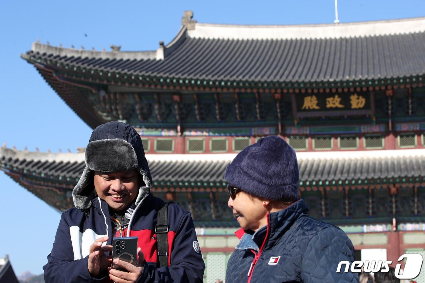 서울 종로구 경복궁을 찾은 외국인 관람객들이 사진을 살펴보고 있다. 2023.12.3/뉴스1 ⓒ News1 이승배 기자