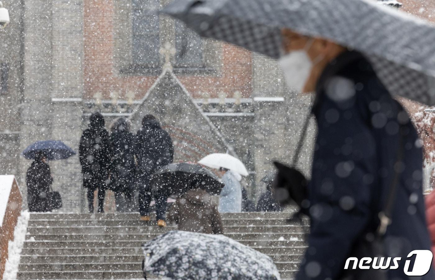 서울 전역에 대설주의보가 발효된 30일 서울 중구 명동성당으로 시민들이 들어가고 있다. 2023.12.30/뉴스1 ⓒ News1 이재명 기자