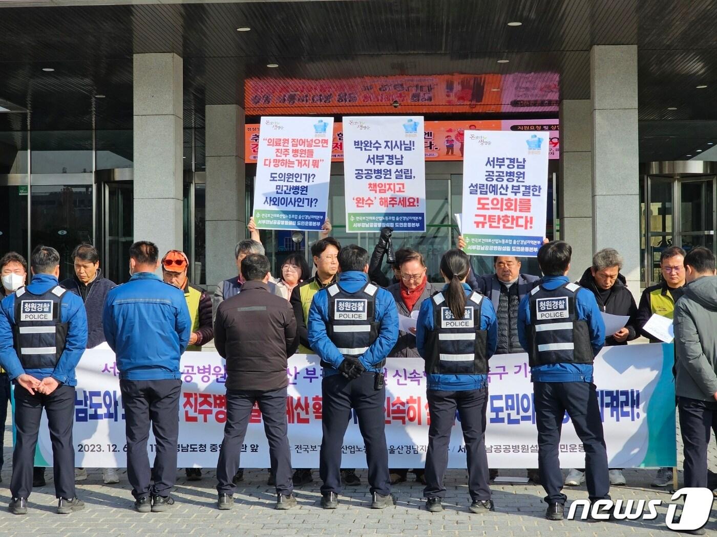 경남 보건의료노조와 서부경남 공공병원 설립 도민운동본부가 6일 경남도청 앞에서 기자회견을 열고 도의회의 공공병원 부지 매입, 설립 예산 부결을 규탄하는 가운데 도청 청원경찰이 회견을 가로막고 있다.  2023.12.6 ⓒ 뉴스1 박민석 기자