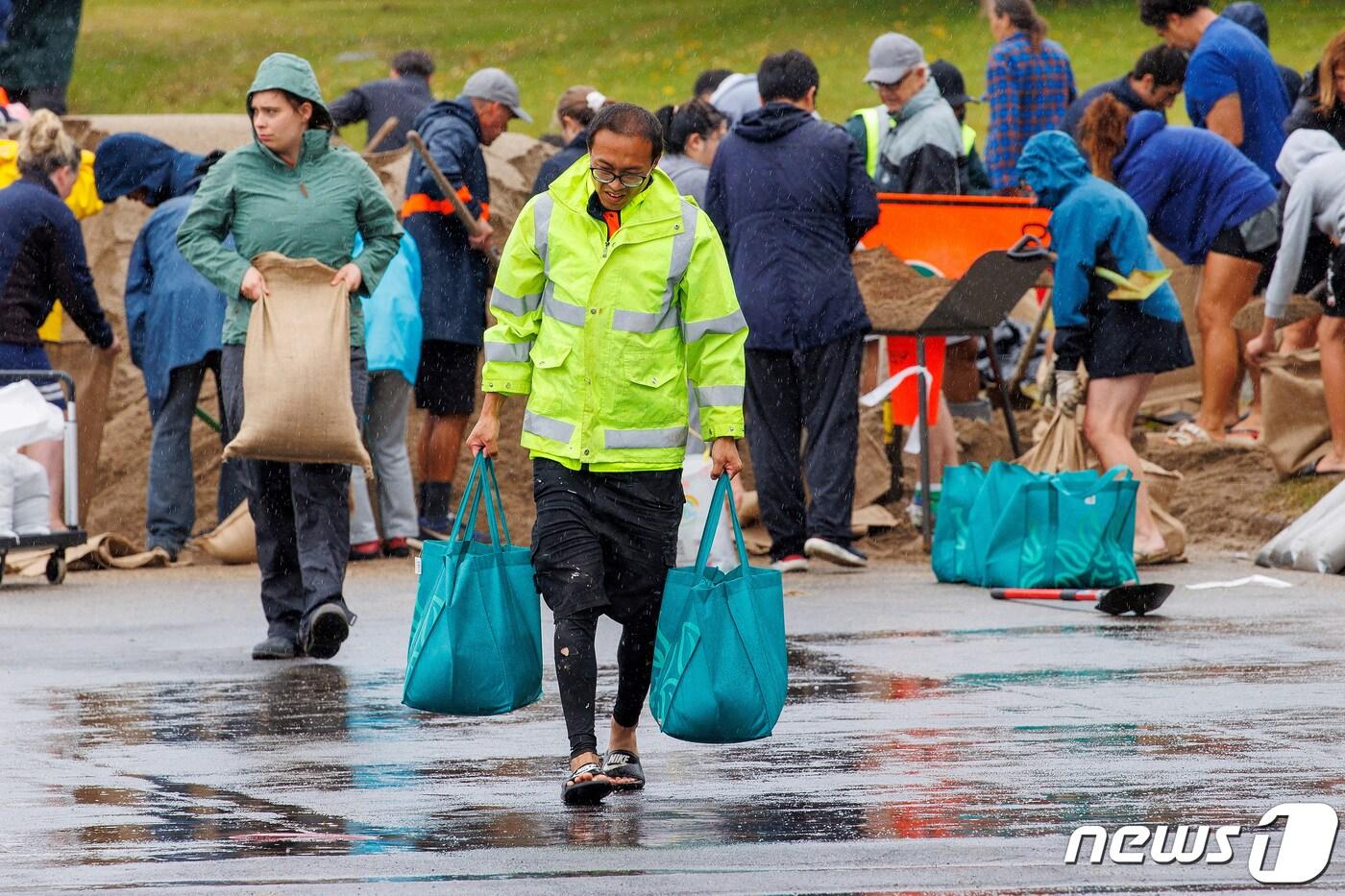폭우 상륙을 앞둔 12일&#40;현지시간&#41; 뉴질랜드 오클랜드에서 주민들이 모래 주머니를 비상 대피소 앞에 쌓고 있다. 2023.02.12. ⓒ 로이터=뉴스1 ⓒ News1 김성식 기자